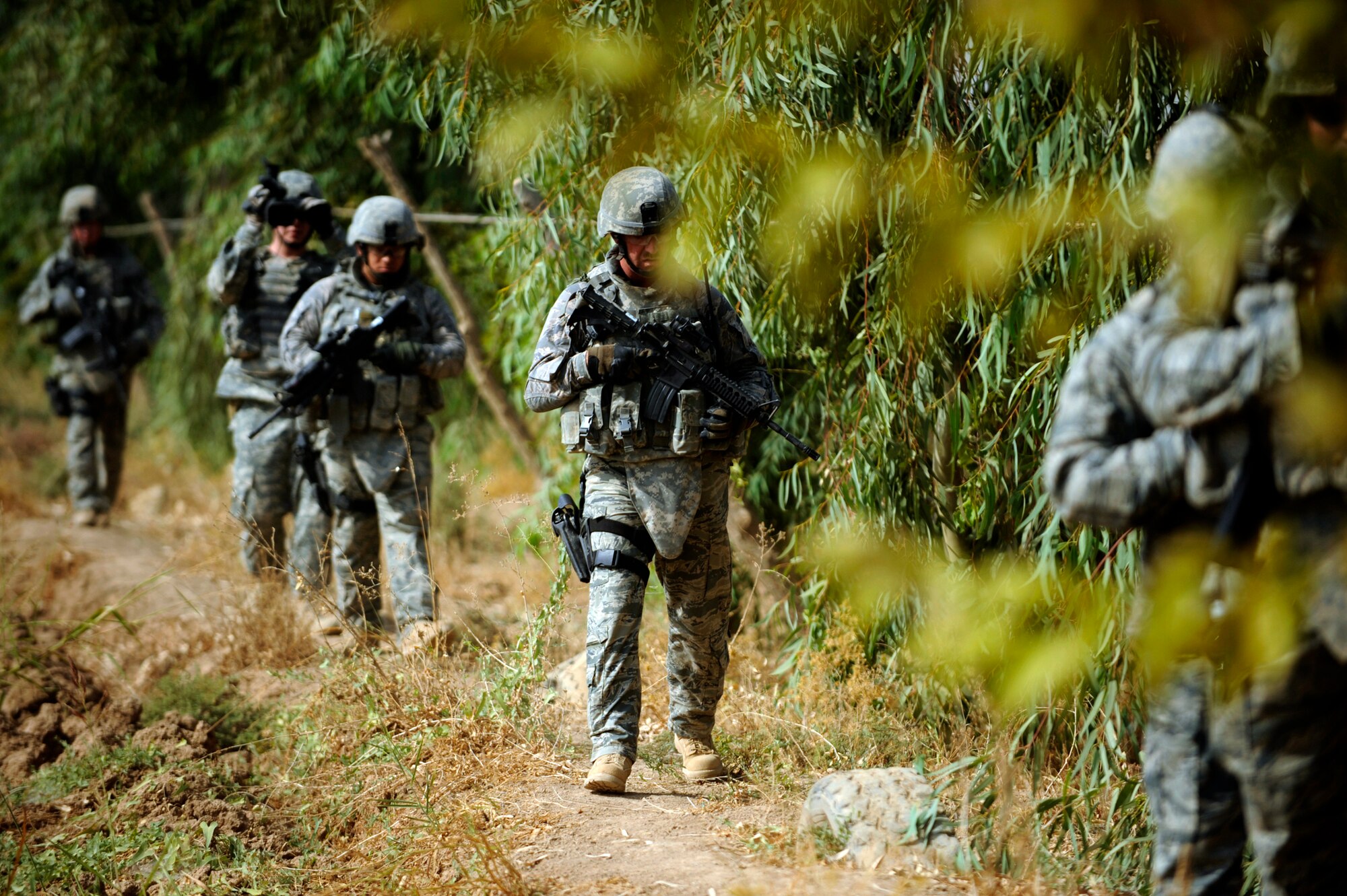 Airmen from the 532nd Expeditionary Security Forces Squadron search a field during a force protection patrol Oct. 17, 2009, outside Joint Base Balad, Iraq. Members of the 532nd Expeditionary Security Forces Squadron patrol to provide a security presence intended to deter anyone who would do harm to the people who live and work at the base. (U.S. Air Force photo/Staff Sgt. Michael B. Keller) 

