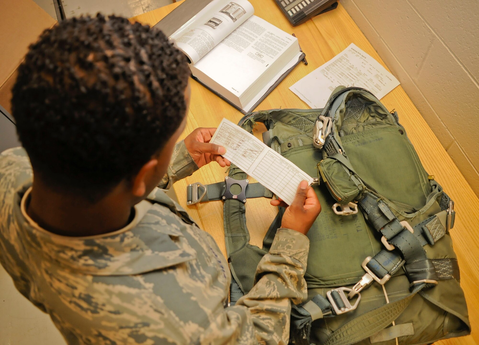 CANNON AIR FORCE BASE, N.M. -- Senior Airman Patrick Fields, 27th Special Operations Support Squadron, prepares to do a 30-day inpsection on a BA-18 back parachute here, Oct. 26. After each inspection, the inspector annotates and signs the tracking form. Each life support member is in charge of inspecting each pilots equipment before use. (U.S. Air Force photo/ Senior Airman Erik Cardenas)