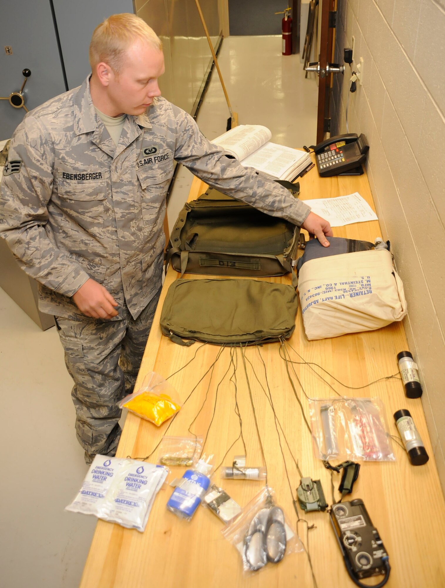 CANNON AIR FORCE BASE, N.M. -- Senior Airman Richard Ebensberger, 27th Special Operations Support Squadron, inspects a surival kit for operational use here, Oct. 26. The kit is attached to the bottom of the BA-18 back parachute and is used in case of emergency. (U.S. Air Force photo/ Senior Airman Erik Cardenas) 