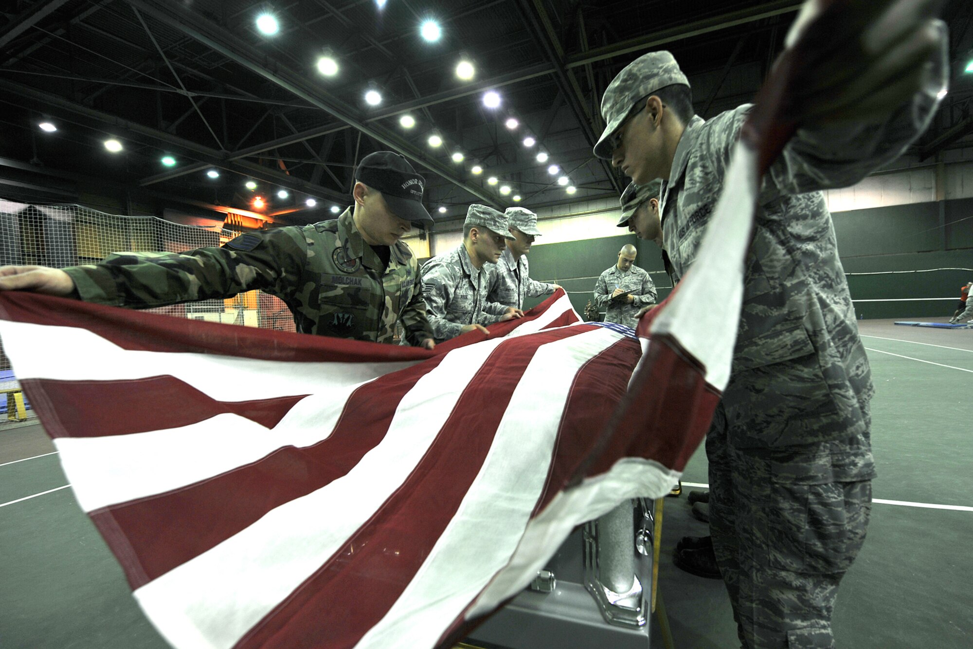OFFUTT AIR FORCE BASE, Neb., -- A Member of the Air Force Honor Guard evaluates members of Offutt's Honor Guard, as well as honor guard members from various installations as they drape an America Flag across a coffin during honor guard training at the Martin Bomber Building here Oct. 21. The Air Force Honor Guard visited Offutt to evaluate and help sharpen the skills of honor guard members from various bases. U.S. Air Force Photo by Charles Haymond