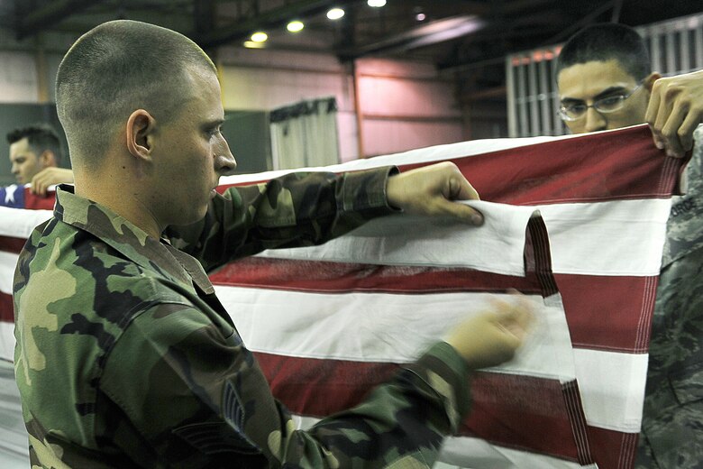 OFFUTT AIR FORCE BASE, Neb., -- Staff Sgt. Aaron Molchak, 55th Force Support Squadron and Staff Sgt. Shane Flot, 55th Strategic Communications Squadron, fold an American Flag during an Air Force Honor Guard training session at the Martin Bomber Building here Oct. 21. The Air Force Honor Guard visited Offutt to evaluate and help sharpen the skills of honor guard members from Offutt, as well as other bases. U.S. Air Force Photo by Charles Haymond