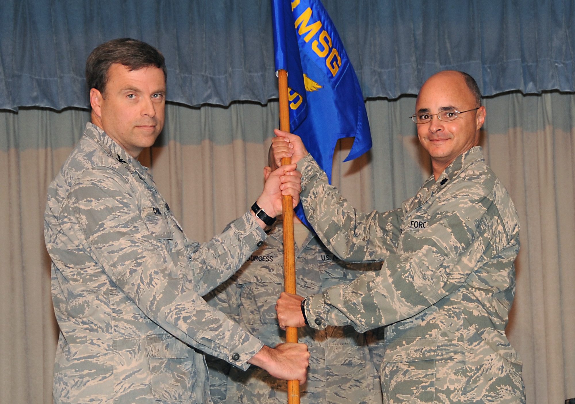 ELMENDORF AIR FORCE BASE, Alaska -- Col.Mark Chance, 3rd Mission Support Group commander, hands off the 3rd Force Support Squadron's guide on to Lt. Col. Derek Contreras, the new 3rd FSS commander Oct. 23. Elmendorf's 3rd Mission Support Squadron and 3rd Services Squadron were officially merged into the 3rd FSS at a ceremony held at the Susitna Conference Center. (U.S. Air Force photo/Senior Airman Cynthia Spalding) 