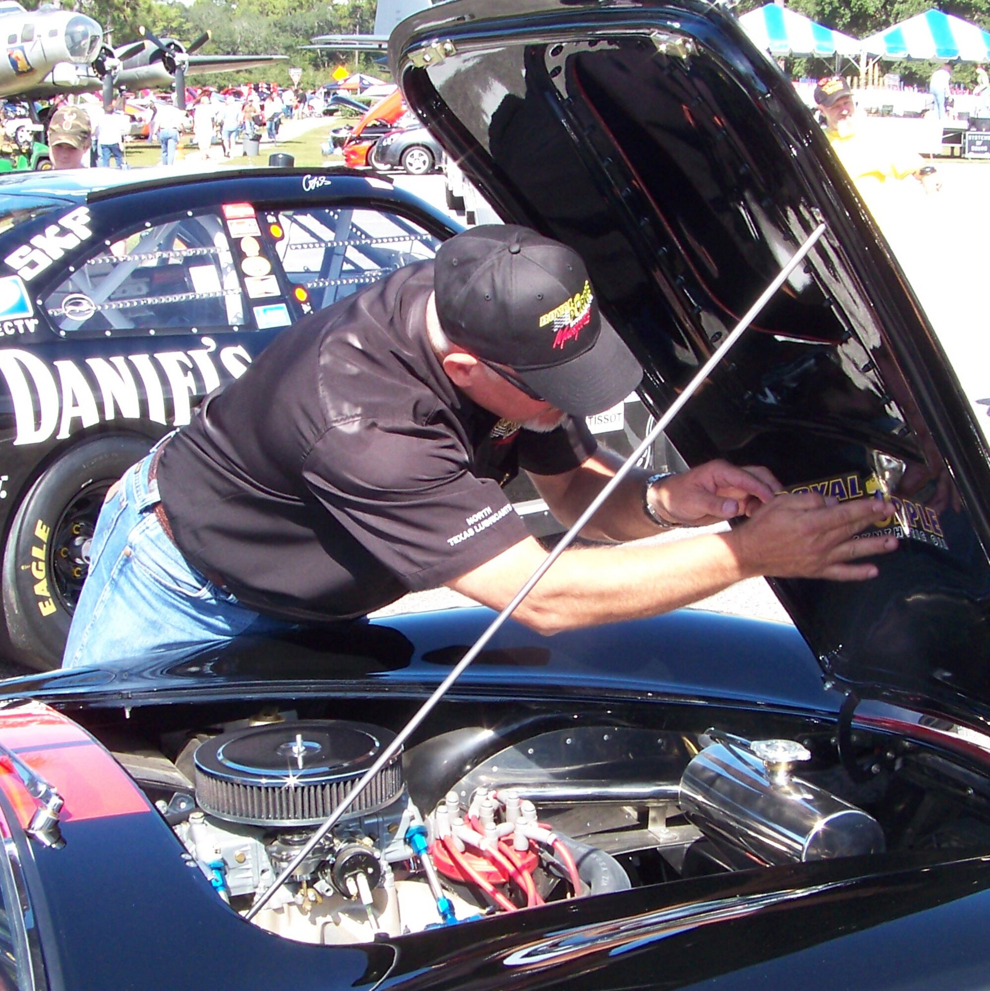 A man affixes a decal under the hood of a Ford Shelby at the 2009 Commando Cruise-In at the Air Force Armament Museum Oct. 24. Several owners had unique custom designs and logos branded on their cars for the show. (U.S. Air Force photo by Airman 1st Class Joe McFadden.)