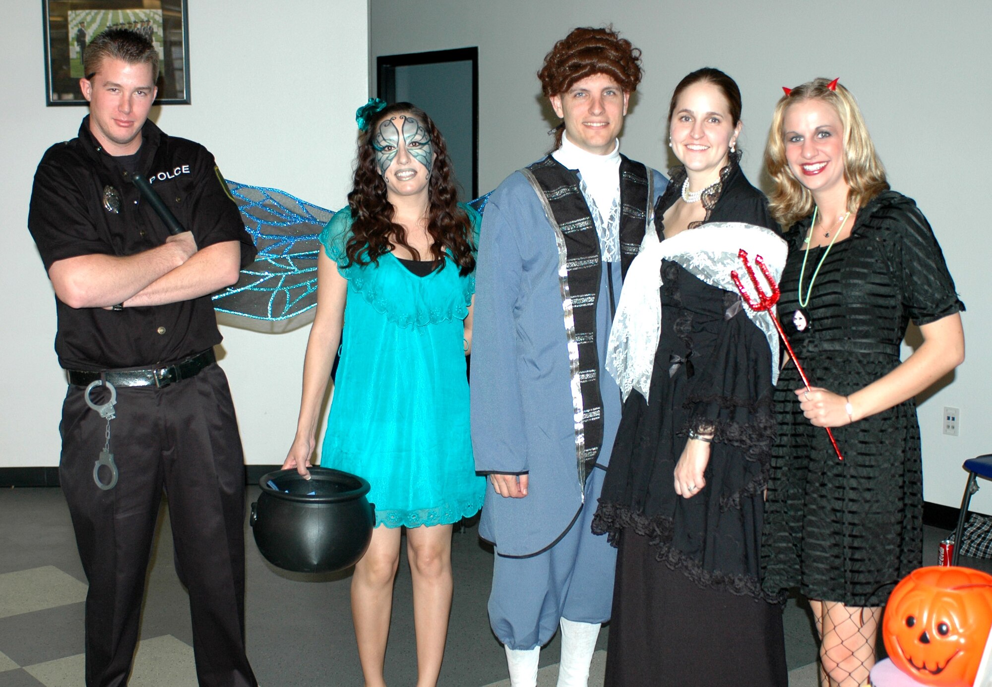 (From the left) Airman First Class Andrew Czarnowski, Staff Sgt. Robin Hinton, Brian Estes, Tech. Sgt. Heidi Estes, and Holly Thiel dress in Halloween costumes to man the Junior Enlisted Council’s cake walk booth in the dining facility. (Air National Guard photo by Maj. Gabe Johnson)