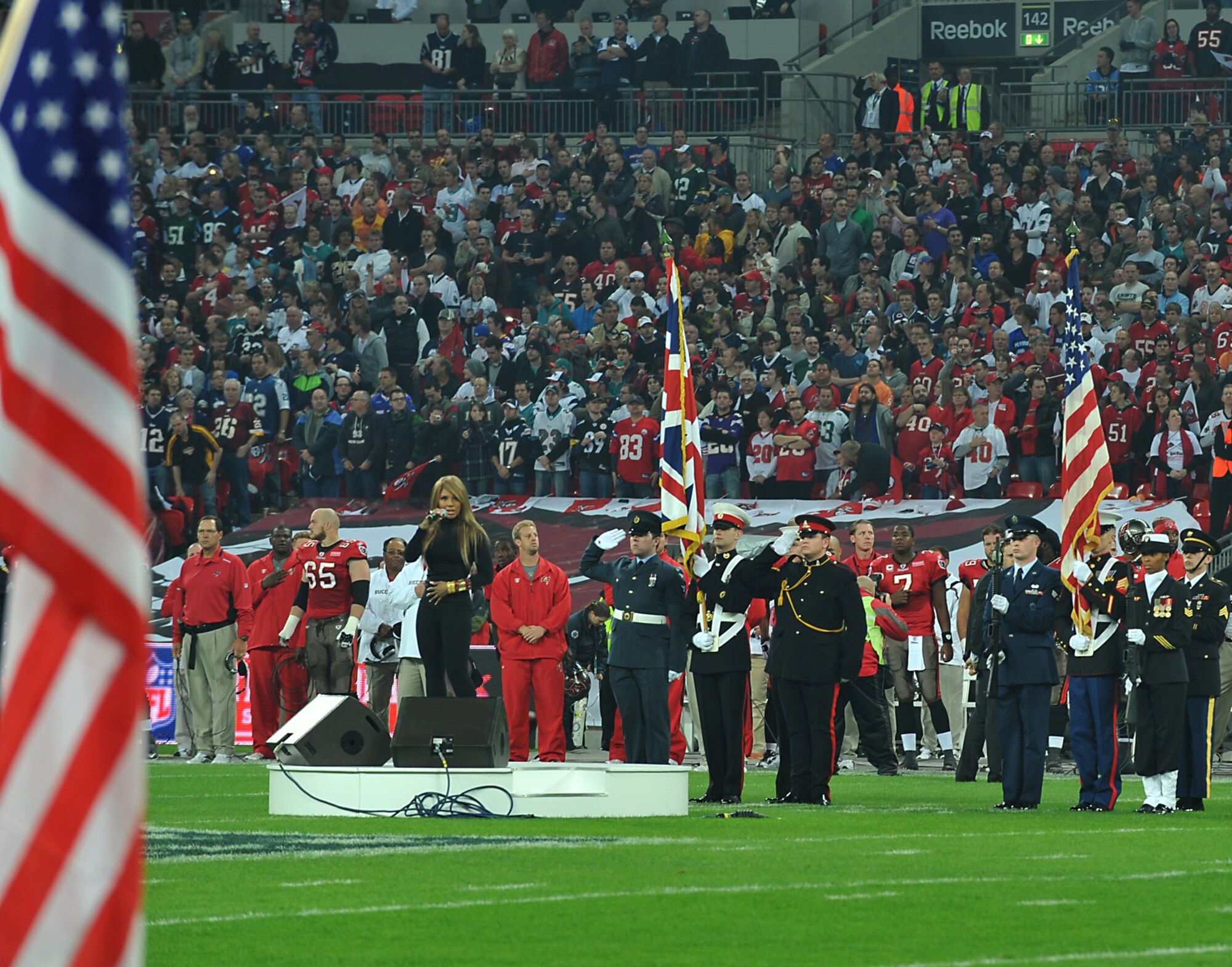 JAC Joint Honor Guard and British Joint Color Guard present the Colors of both nations at the NFL game at Wembley Stadium as pop star Toni Braxton sings the Star Spangled Banner.   (Photo by Air Force Staff Sgt. Javier Cruz)