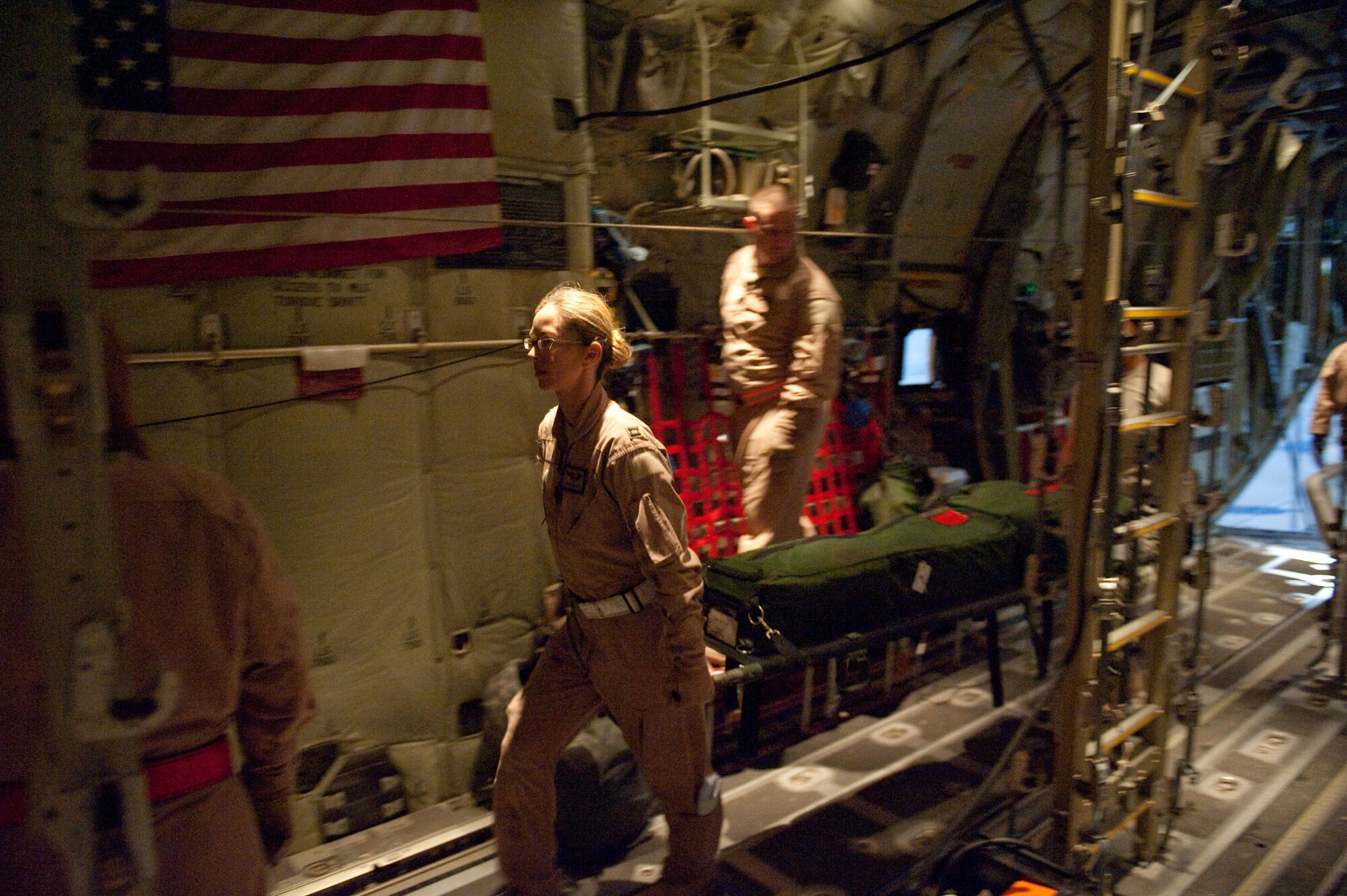Capt. Christine Love, 379th Expeditionary Aeromedical Evacuation Squadron flight nurse, loads medical equipment with fellow 379 EAES members onto a C-130J Hercules in preparation for patients, Oct. 24, 2009, in Southwest Asia. The 379 EAES provides a regular "mercy mission" that transports patients from throughout Southwest Asia to established medical care facilities in support of operations Iraqi Freedom and Enduring Freedom. (U.S. Air Force photo/Staff Sgt. Robert Barney) 