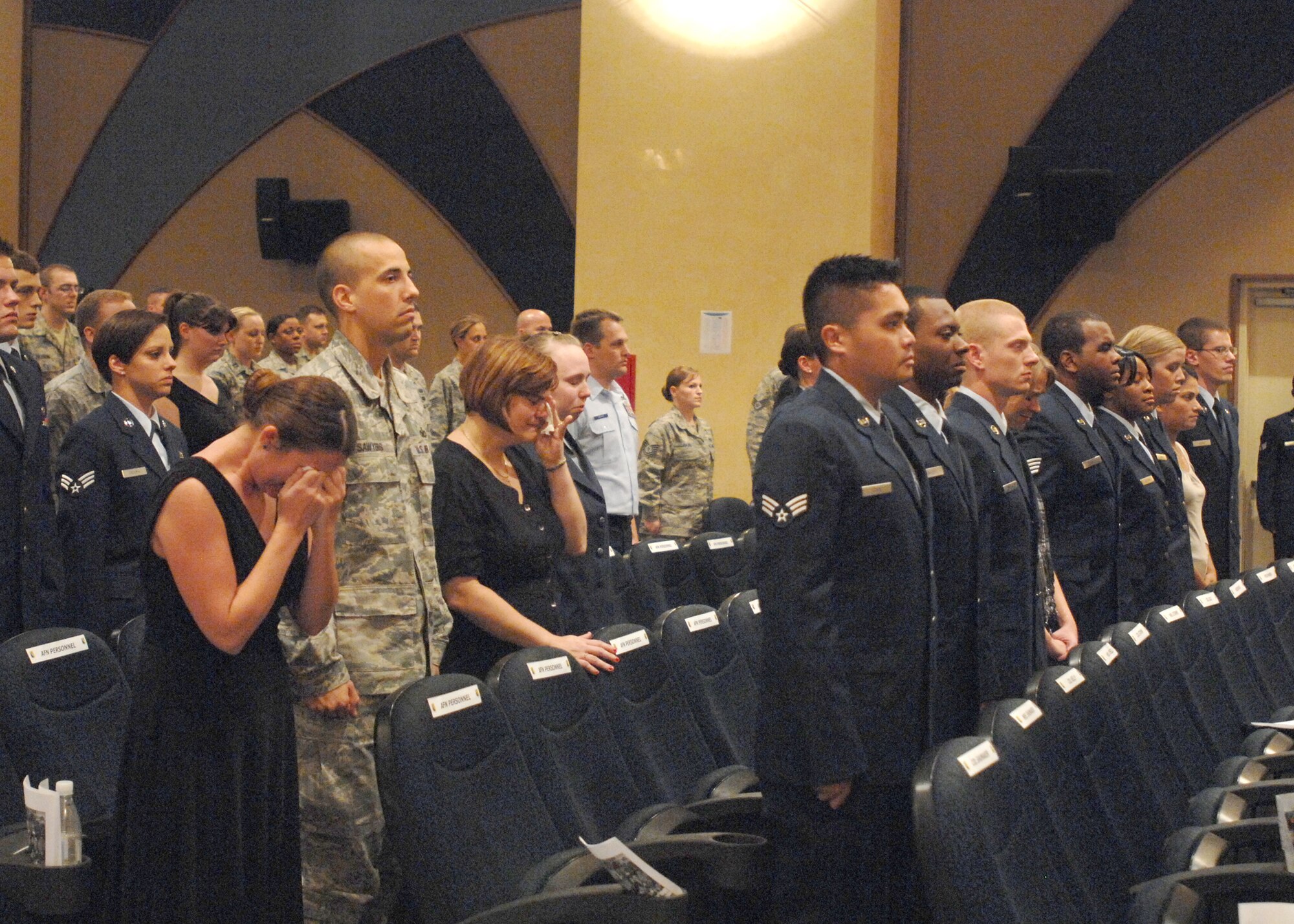 Friends and coworkers of Airman 1st Class Lauren Lagudi stand during a role call conducted by Master Sgt. Andrew Henne during the memorial service held in her honor Oct. 26, 2009 at the Aviano Air Base, Italy base theater.  Sergeant Henne, 31st Force Support Squadron first sergeant, called out Airman Lagudi’s name three times with no response before “TAPS” was played by a bugler from the 31st Fighter Wing base honor guard.  Airman Lagudi was a broadcaster assigned American Forces Network Aviano affiliate.  (U.S. Air Force photo Senior Airman Tabitha Mans)
