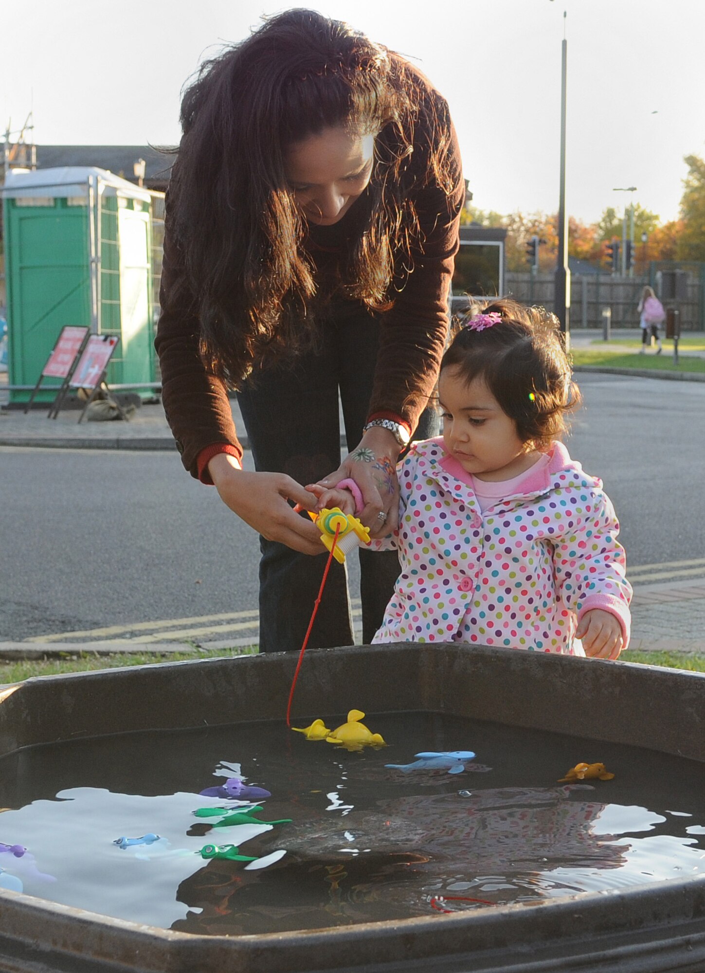 RAF MILDENHALL, England -- Fabiola Flores, military spouse, helps her daughter Isabella, 13 months, catch a fish at the RAF Mildenhall Child Development Center Oct. 23. The Fall Festival is an annual event hosted by the Parent Advisory Committee and offers a variety of carnival-style games and a barbecue for children who attend the CDC here. The committee will host another festival in the spring. They meet once a month to discuss ways to improve the center here. Their meetings are at 4:30 p.m. on the third Wednesday of every month in the CDC's resource room. (U.S. Air Force photo/Senior Airman Thomas Trower)