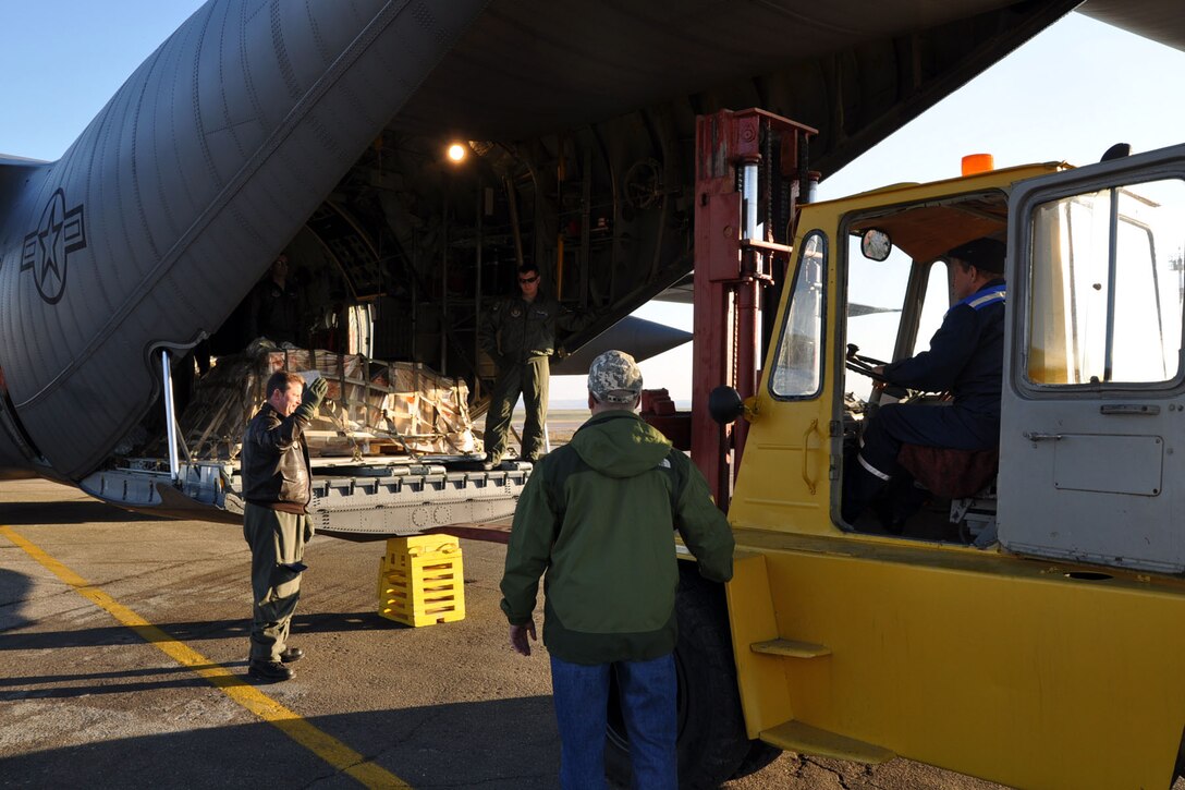 CHISINAU, Moldova -- Air Force Reserve Master Sgt. Mark Zickefoose directs a forklift towards the cargo ramp of a C-130H Hercules tactical cargo transport aircraft, asssigned to the 910th Airlift Wing based at Youngstown Air Reserve Station, Ohio, at the airport here, October 22, 2009. Navigator Lt. Col. Don Loomis (behind cargo pallet) and loadmaster Sr. Airman Brent Bate watch from the interior of the C-130's cargo deck as the forklift approaches the aircraft to unload cargo. These Citizen Airmen and five others from YARS are on an airlift mission delivering passengers and supplies to Chisinau, the capital city of Moldova, located in eastern Europe between Romania and the Ukraine. The aircrew members on this flight are among more than 70 Servicemembers from the 910th AW attached to the 38th Expeditionary Airlift Squadron, based here. The 38th EAS is supporting Operation Joint Enterprise by providing tactical airlift capability to locations in the U.S. Europe Command (EUROCOM), U.S. Africa Command (AFRICOM) and U.S. Central Command (CENTCOM) theaters of operations. U.S. Air Force photo by Master Sgt. Bob Barko Jr.