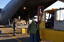 CHISINAU, Moldova -- Air Force Reserve Master Sgt. Mark Zickefoose directs a forklift towards the cargo ramp of a C-130H Hercules tactical cargo transport aircraft, asssigned to the 910th Airlift Wing based at Youngstown Air Reserve Station, Ohio, at the airport here, October 22, 2009. Navigator Lt. Col. Don Loomis (behind cargo pallet) and loadmaster Sr. Airman Brent Bate watch from the interior of the C-130's cargo deck as the forklift approaches the aircraft to unload cargo. These Citizen Airmen and five others from YARS are on an airlift mission delivering passengers and supplies to Chisinau, the capital city of Moldova, located in eastern Europe between Romania and the Ukraine. The aircrew members on this flight are among more than 70 Servicemembers from the 910th AW attached to the 38th Expeditionary Airlift Squadron, based here. The 38th EAS is supporting Operation Joint Enterprise by providing tactical airlift capability to locations in the U.S. Europe Command (EUROCOM), U.S. Africa Command (AFRICOM) and U.S. Central Command (CENTCOM) theaters of operations. U.S. Air Force photo by Master Sgt. Bob Barko Jr.