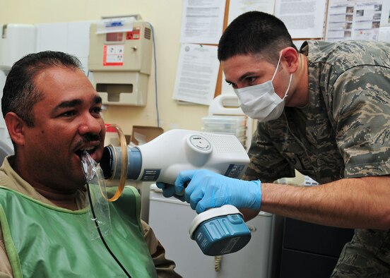 SOUTHWEST ASIA -- Staff Sgt. Emmanuel Gonzales, 386th Expeditionary Medical Support dental technician, uses a Nomad hand held digital x-ray machine on a patient at an airbase in Southwest Asia Oct. 27, 2009.  Sergeant Gonzales is deployed from the 88th Dental Squadron, Wright-Patterson Air Force Base, Ohio and hails from Phoenix.  (U.S. Air Force photo/Tech. Sgt. Tony Tolley)