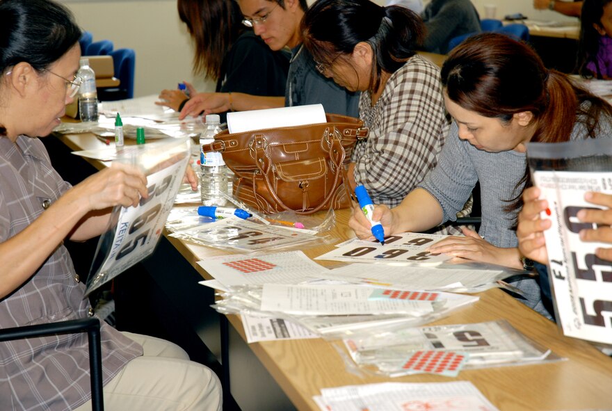 American and Japanese volunteers package T-shirts Oct. 24 for athletes who will compete at the 10th Anniversary Kadena Special Olympics, set to take place Nov. 14 at Kadena Air Base, Japan. (Courtesy photo/Banji Shimoji)