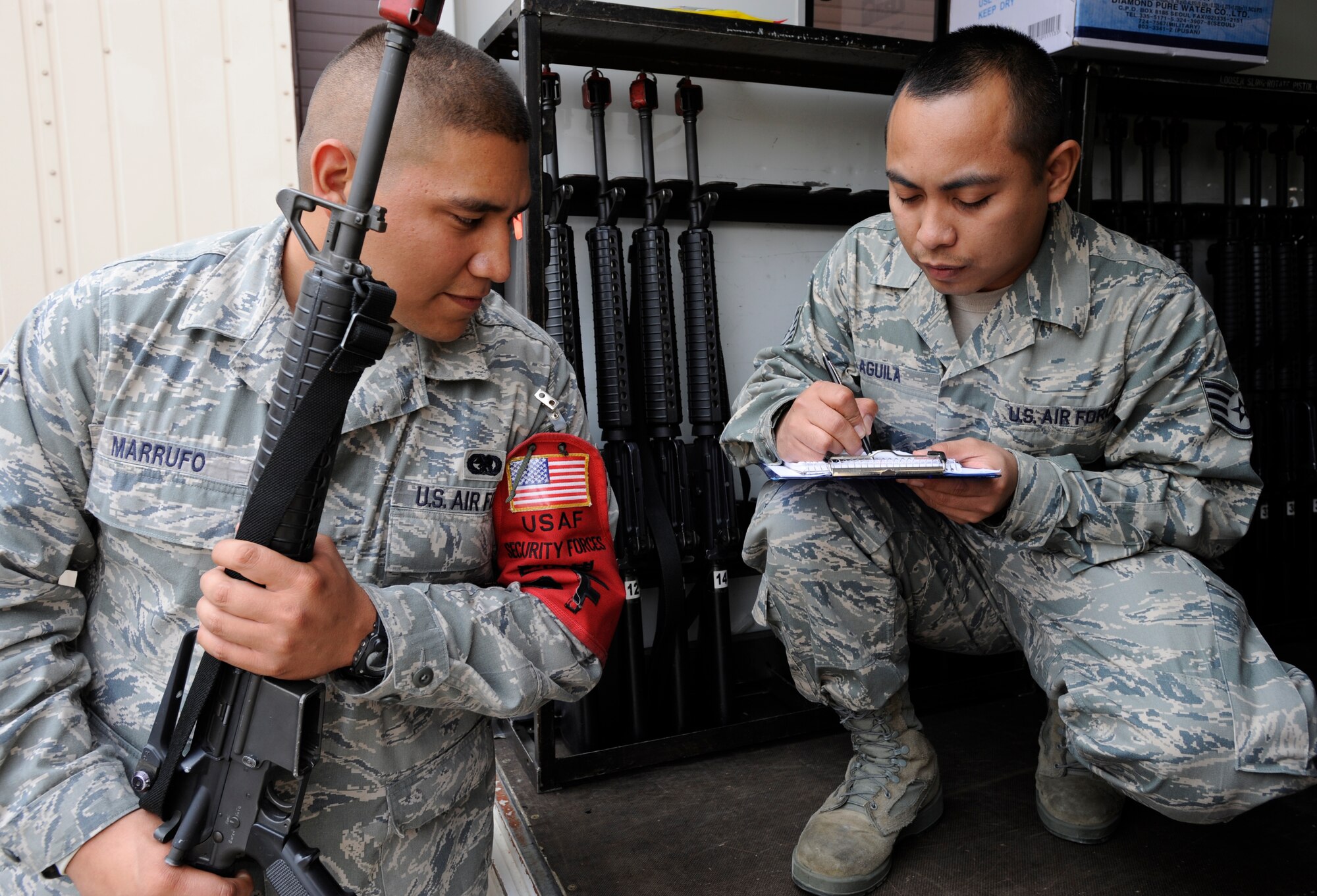 Staff Sgt. Eugene Aguila, right, writes down serial numbers as Senior Airman Daniel Marrufo reads the number to him. This is done for accountability prior to handing over the weapons during the 51st Logistics Squadron pre-Operational Readiness Exercise training held here Oct. 15-16. SSgt Aguila and Sra Marrufo are vehicle operators with the 51st Logistics Readiness Squadron. (Air Force photo/Senior Airman Stephanie Wade)