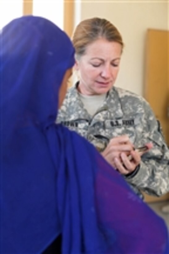 U.S. Army Maj. Carla Brown prescribes medications for an Afghan teenager during a medical civil assistance program at the Nerkh District Center in the Wardak province, Afghanistan, on Oct. 21, 2009.  Brown is a doctor, assigned to Charlie Company, 710th Medical Battalion, attached to 2nd Battalion, 87th Infantry Regiment, 3rd Brigade Combat Team, 10th Mountain Division.  