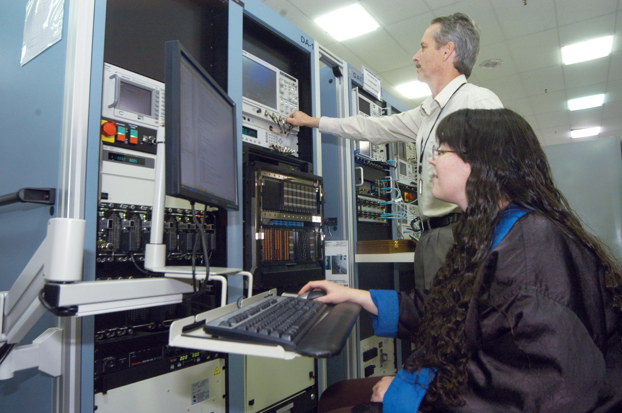 Tom Moltz, electronics technician, and Christy Matkey, electronics engineer, run a newly developed test program on a VDATS test station. U. S. Air Force photo by Sue Sapp     