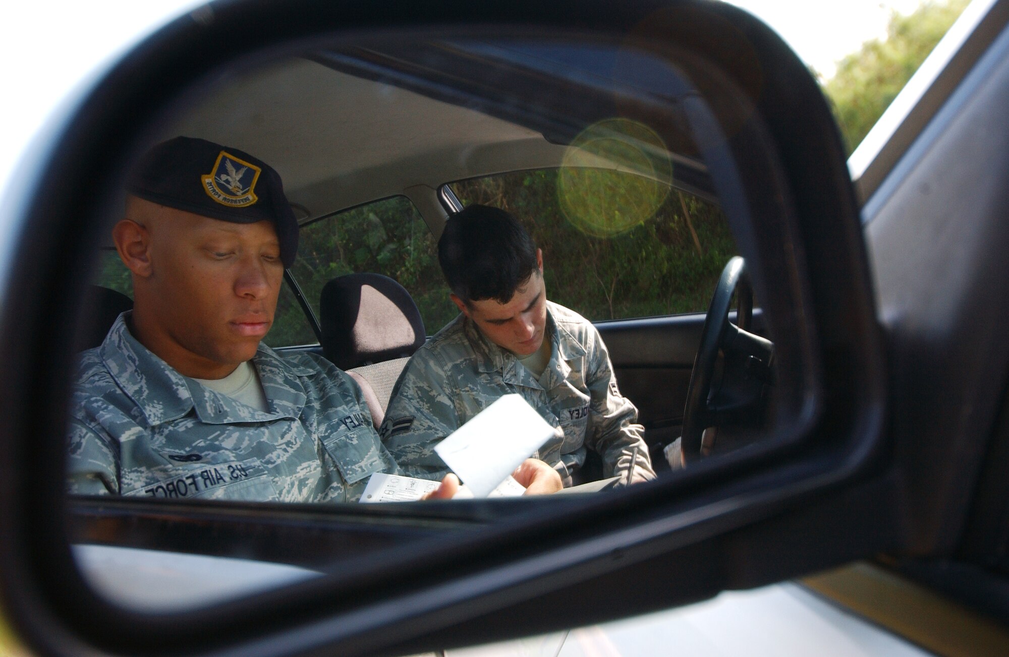 Airman 1st Class Edward Bailey and Airman 1st Class Laurence Bradley write tickets for drivers not abiding by the traffic laws Oct. 27 at Kadena Air Base, Japan. The Airmen are part of a traffic enforcement team to keep a safe and secure environment for all personnel on the installation.   (U.S. Air Force photo/Tech. Sgt. Rey Ramon)    
