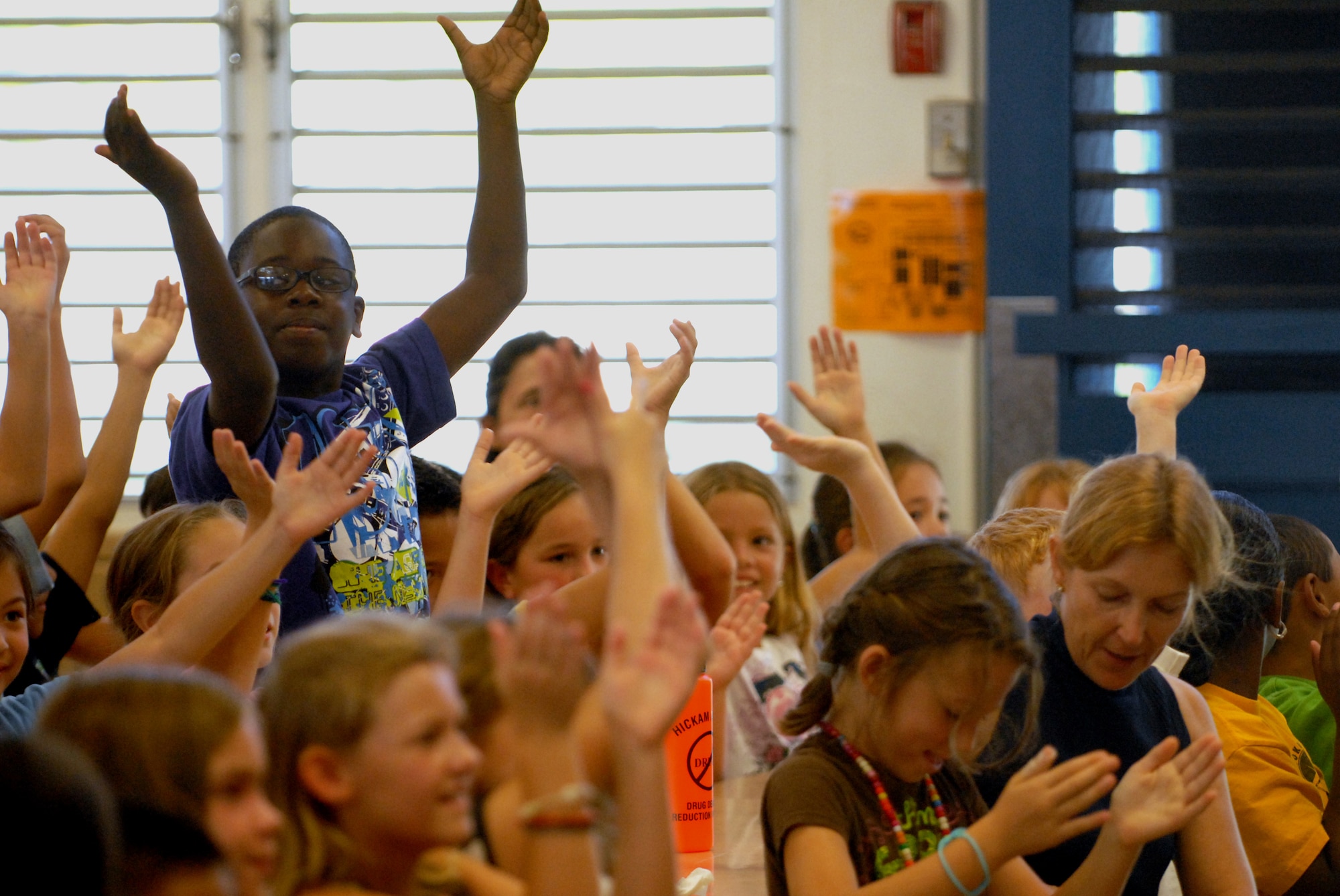 HICKAM AIR FORCE BASE, Hawaii -- Students from Mokulele Elementary School clap their hands and dance during a performance put on by the U.S. Air Force Band of the Pacific here Oct. 28. Mokulele, one of two elementary schools on Hickam, was one of six schools the band performed for in support of Red Ribbon Week. Red Ribbon Week focuses on living and maintaining a drug free lifestyle. (U.S. Air Force photo/Senior Airman Gustavo Gonzalez)