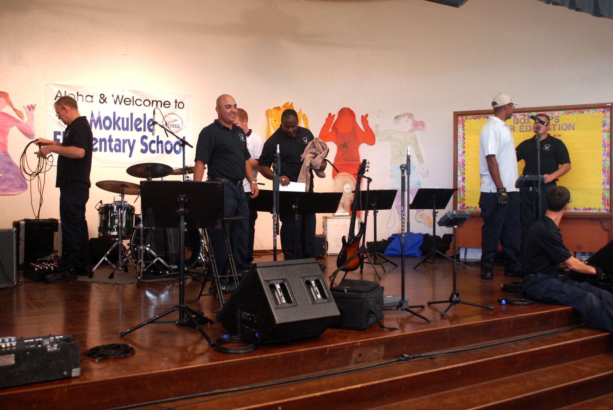 HICKAM AIR FORCE BASE, Hawaii -- U.S. Air Force Band of the Pacific band members set the stage up at Mokulele Elementary School before performing here Oct. 28. Mokulele, one of two elementary schools on Hickam, was one of six schools the band performed for in support of Red Ribbon Week. Red Ribbon Week focuses on living and maintaining a drug free lifestyle. (U.S. Air Force photo/Senior Airman Gustavo Gonzalez)