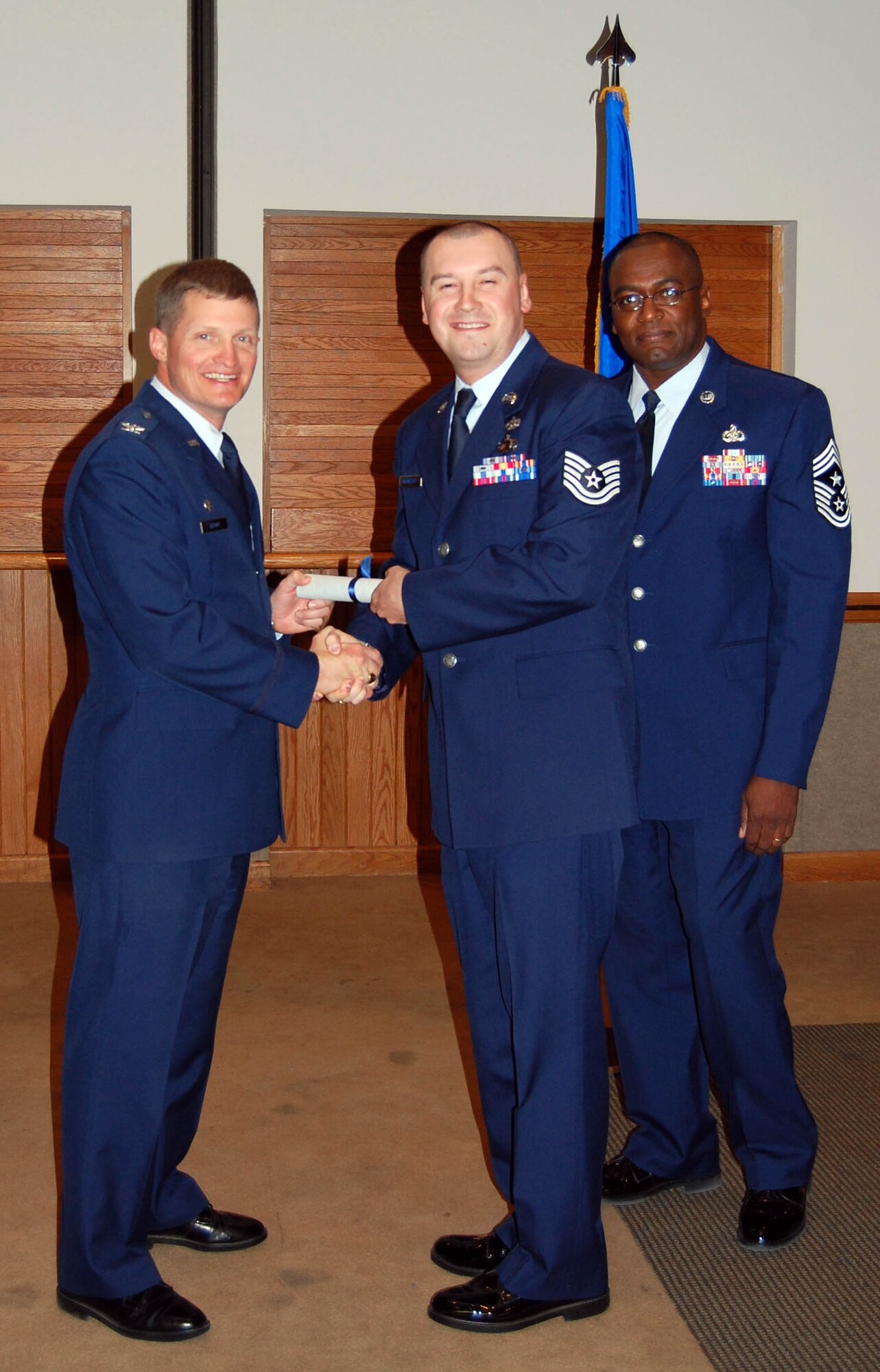 (Middle) Tech. Sgt. Lee McKinstry, 926th Mission Support Squadron, receives his Associate in Applied Science Degree in Education and Training Management from Col. Howard Belote, 99th Air Base Wing commander (left), during the Community College of the Air Force commencement ceremony here Oct. 27. As the education and training manager, Sergeant McKinstry oversees all aspects of education and training programs for 926th Group personnel to include managing the development of instructional products, planning, directing, organizing and coordinating operations of the Advance Distributed Learning system and multimedia education programs, and monitoring the accuracy and reliability of data in the Military Personnel Data System. (U.S. Air Force Reserve photo/Capt. Jessica Martin)