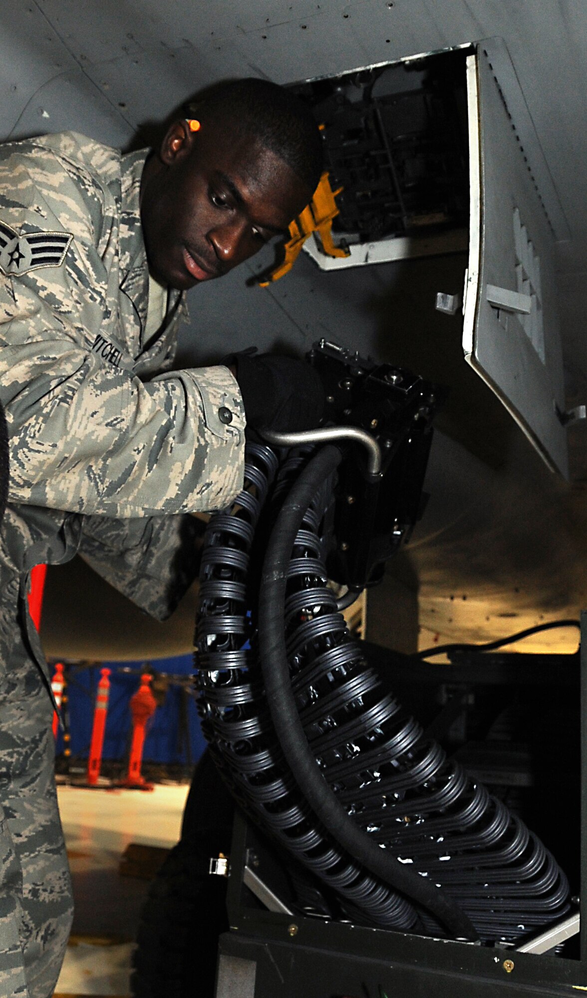 ELMENDORF AIR FORCE BASE, Alaska -- Senior Airman Mitch Mitchell positions a Linkless Ammunition Loading System to the 20mm gun system interface unit on the F-15 during certification training Oct. 26. Airmen must be certified on missile loading once a month. Mitchell is an aircraft armament systems specialist with the 19th Aircraft Maintenance Unit. (U.S. Air Force photo/Senior Airman Cynthia Spalding)