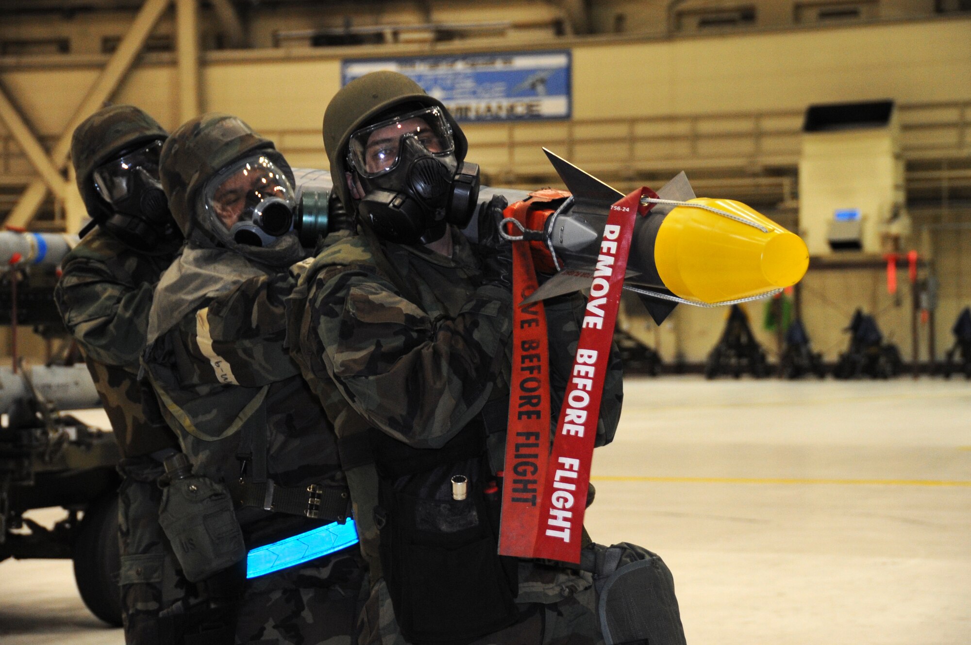 ELMENDORF AIR FORCE BASE, Alaska -- A weapons crew wearing personal protective equipment carries an air intercept missile 9 during certification training Oct. 23. Wearing PPE during a weapons load is part of initial certification and must be done once a year. Members are aircraft armament systems specialists with the 19th Aircraft Maintenance Unit. (U.S. Air Force photo/Senior Airman Cynthia Spalding) 