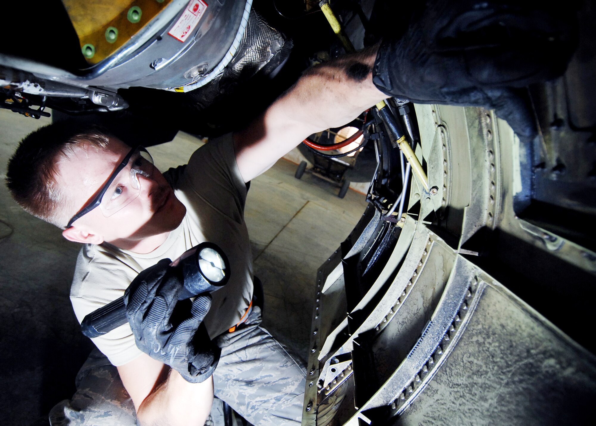 Airman Travis Sharp inspects the lower fuselage of an F-16 Fighting Falcon at Joint Base Balad, Iraq, Oct. 20, 2009.  Airman Sharp is a crew chief with the 332nd Expeditionary Maintenance Squadron.  (U.S. Air Force photo/Senior Airman Christopher Hubenthal) 