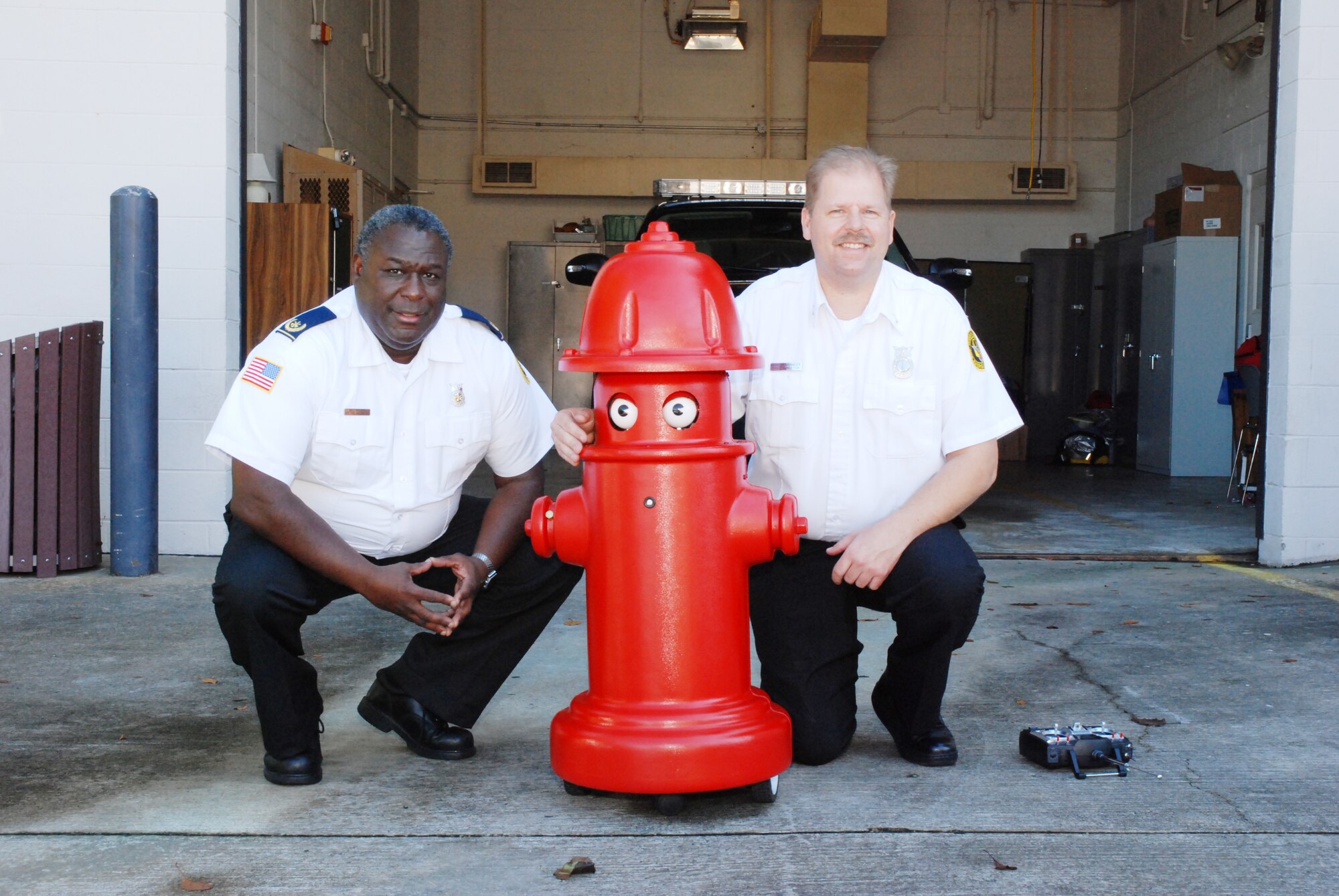 Assistant Fire Chief Bill Wilson and Fire Protection Inspector Mark Berkenmeier introduces the newest member of  DARB Fire Emergency Services fire prevention team --“Pluggie The Fire Plug.” (U.S. Air Force photo/Master Sgt. Stan Coleman)