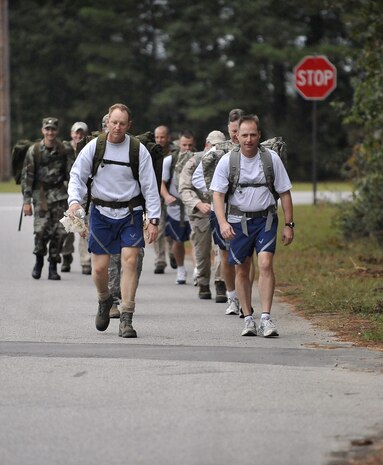 Col. John Wood, right, and Col. Benjamin Wham and lead 437th Civil Engineer Squadron Explosive Ordnance Disposal Flight members on a ruck march here Oct. 27. The EOD personnel train with ruck sacks to prepare for embedding with sister services and foreign special forces in a dismounted capacity while deployed. Colonel Wood is the 437th Airlift Wing commander and Colonel Wham is the 437th Mission Support Group commander. (U.S. Air Force photo/James Bowman)
