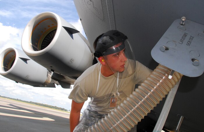 Airman 1st Class Bryan Mathey trains on the proper procedures for connecting a waste hose to a C-17 during a lavatory servicing operation on the flightline here Oct. 28. During lavatory servicing, Airmen must wear gloves, a face shield and an apron to protect themselves from the 11 gallons of hazardous fluid pumped into the aircraft used to clean and disinfect the lavatory system. Airman Mathey is a student enrolled in the 437th Aerial Port Squadron's Port Dawg University. (U.S. Air Force photo/Staff Sgt. Daniel Bowles)