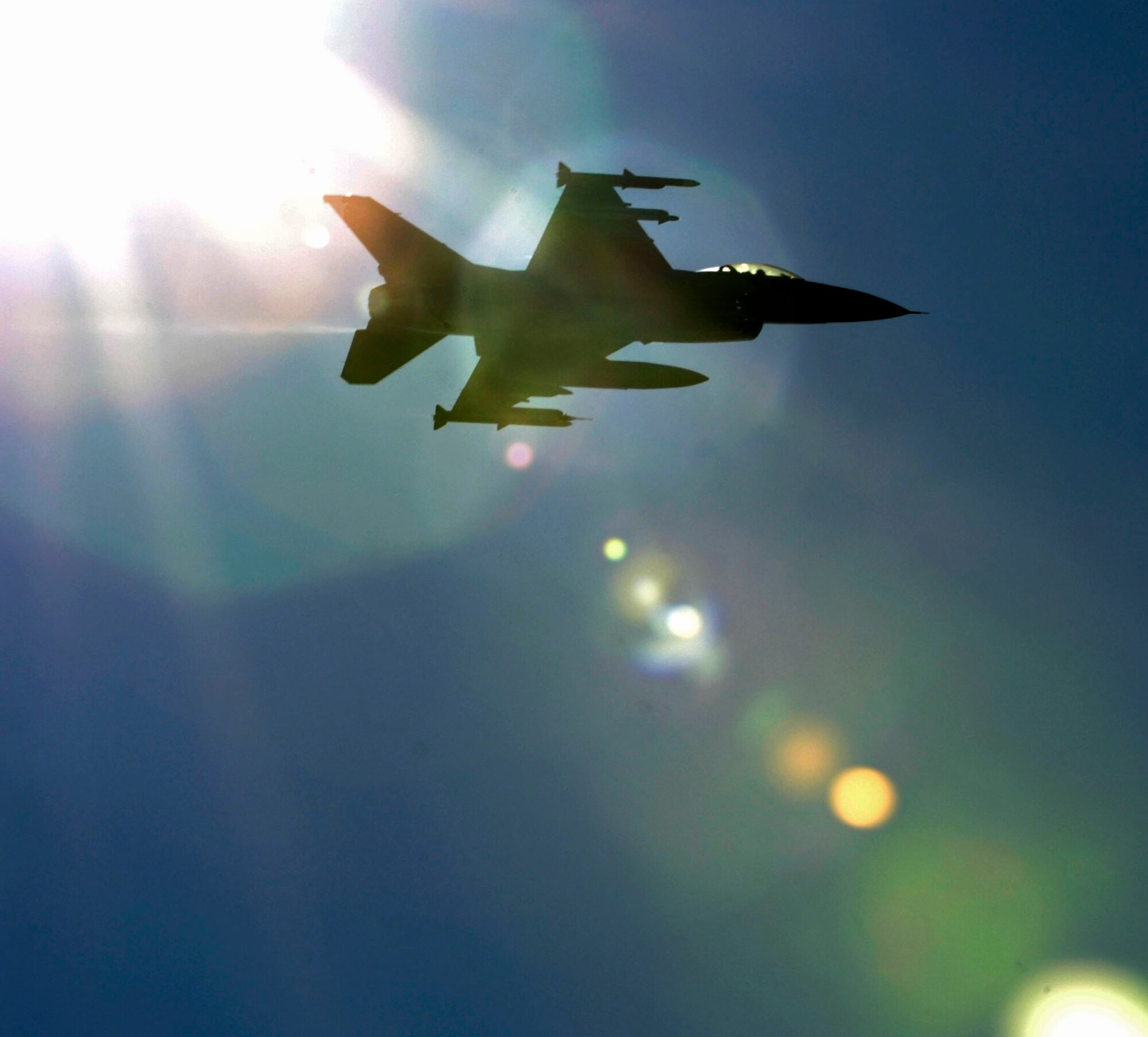 LANGLEY AIR FORCE BASE, Va. – An F-16C Fighting Falcon piloted by Maj. John Wilcox, Air Combat Command Inspector General F-16 Operations inspector, is shown silhouetted against the sun during takeoff here Oct. 28. The fighter jet carries a fourth generation advanced targeting LITENING pod, this is the first test during a two week exercise called Bold Quest 2009, an advanced concept technology demonstration.(U.S. Air Force photo/Airman Rebecca Montez)