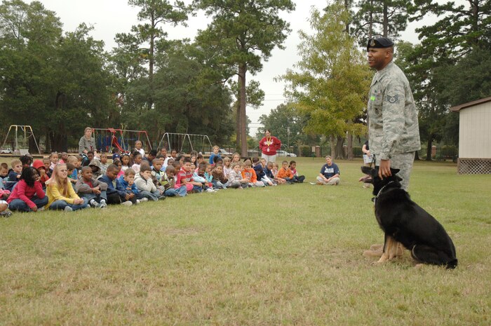 Staff Sgt. Ramon Alexander answers question from the students and faculty at Hunley Park Elementary after a drug search demonstration held at the school, Oct. 27. The 437th Security Forces Squadron's military working dog kennels conducted the demonstration as part of Red Ribbon week which raises public awareness and mobilize communities to combat tobacco, alcohol and drug use among military personnel, civilians and their families. Sergeant Alexander is a dog handler with the 437 SFS. (U.S. Air Force photo/Staff Sgt. Marie Brown)