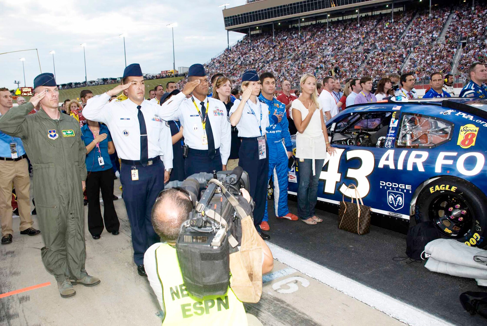 Second and third from left, Tech. Sgt. Rick Jones and Senior Master Sgt. Gregory Walker of Air Force Recruiting Service, along with visiting Air Force leaders salute during the playing of the National Anthem at the Atlanta Motor Speedway in Atlanta Sept. 6, 2009. (U.S. Air Force photo/Ronn Linn) 
