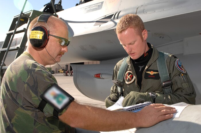 NELLIS AIR FORCE BASE, Nev. -- 1st Sgt. Eerde Adema (crew chief) and 1st Lt. Valks Arend (pilot) from the Royal Netherlands Air Force sign pre-flight checklists before departing on a training mission at Red Flag 10-1.  Red Flag is a realistic combat training exercise involving the air forces of the United States and its allies. The exercise is conducted on the 15,000-square-mile Nevada Test and Training Range, north of Las Vegas. (U.S. Air Force photo by Tech. Sgt. Michael R. Holzworth)(Released)