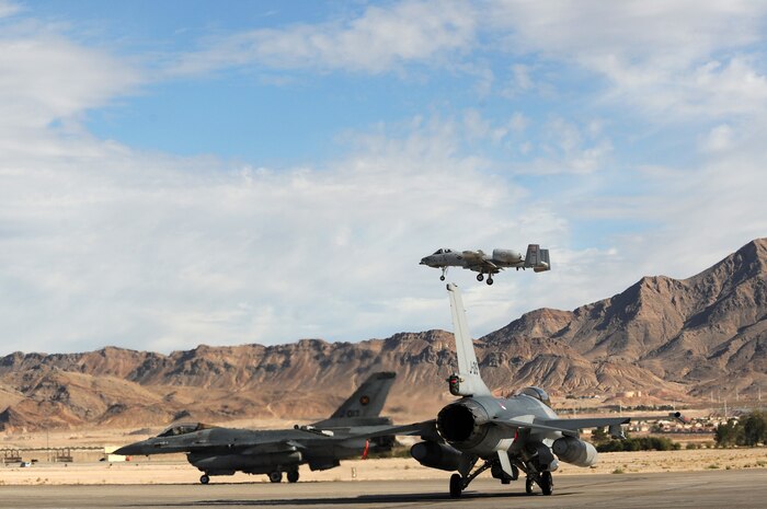 NELLIS AIR FORCE BASE, Nev. -- An A-10 Thunderbolt II "Warthog" assigned to the 188th Fighter Wing, Arkansas Air National Guard lands on the Nellis runway while two F-16AM's from the Royal Netherlands Air Force await clearance from the Nellis tower to depart for a training mission at Red Flag 10-1.  Red Flag is a realistic combat training exercise involving the air forces of the United States and its allies. The exercise is conducted on the 15,000-square-mile Nevada Test and Training Range, north of Las Vegas. (U.S. Air Force photo by Tech. Sgt. Michael R. Holzworth)(Released)