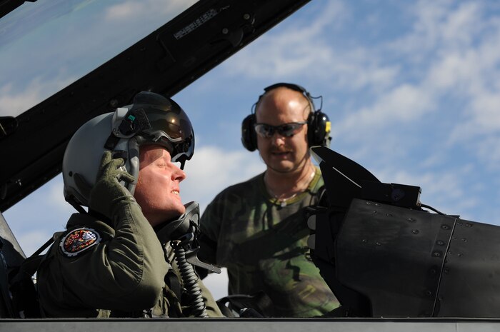 NELLIS AIR FORCE BASE, Nev. -- 1st Sgt. Eerde Adema a crew chief from the Royal Netherlands Air Force looks on as 1st Lt. Valks Arend  puts on his helmet before a training mission at Red Flag 10-1.  Red Flag is a realistic combat training exercise involving the air forces of the United States and its allies. The exercise is conducted on the 15,000-square-mile Nevada Test and Training Range, north of Las Vegas. (U.S. Air Force photo by Tech. Sgt. Michael R. Holzworth)(Released)