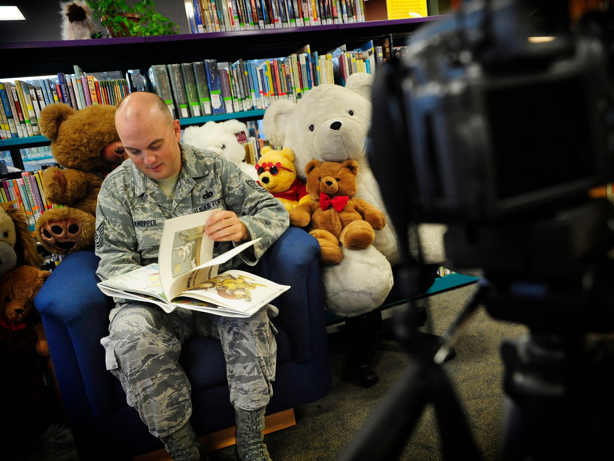 Tech. Sgt. Jason Knepper, 927th Security Forces Squadron, reads the childrens book,  "Where the Wild Things Are" to a video recorder as part of Operation Storytime at the Education Center here Oct. 22. Operation Storytime allows deploying members to record a video of themselves reading a children's story, and give it to their children upon deployment as a way to "read" a bedtime story to them while they are deployed.  (U.S. Air Force photo by Airman First Class Rylan Albright/Released)