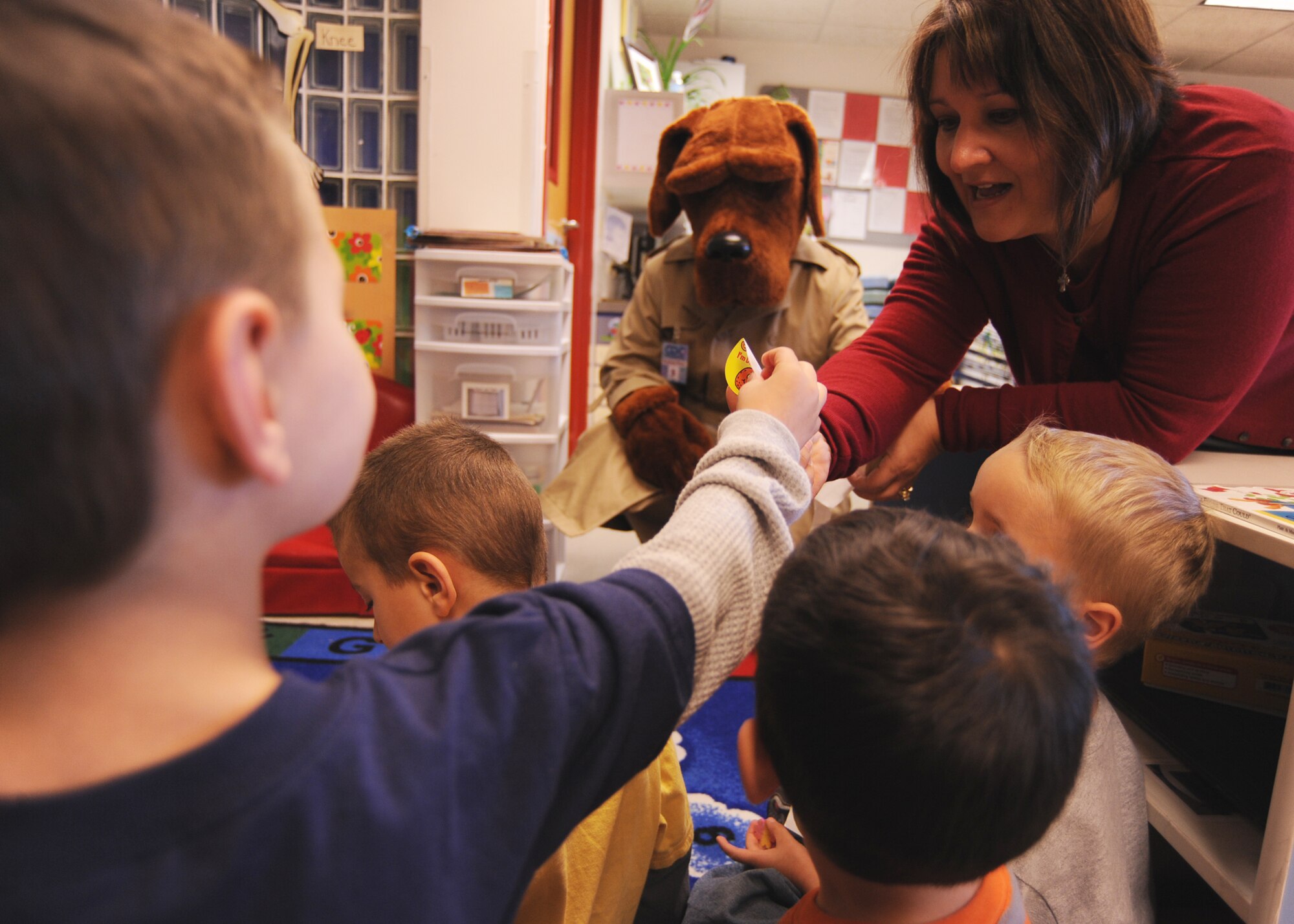 Lisa Bowser, 22nd Medical Operations Squadron Demand Reduction Program manager, gives stickers to children, Oct. 27, 2009, at the McConnell Air Force Base, Kan., Child Development Center in honor National Red Ribbon Week. McGruff the Crime Dog joined Ms. Bowser to talk to children about drug and alcohol prevention. National Red Ribbon Week is the nation’s oldest and largest drug prevention program and runs yearly the last week of October. (U.S. Air Force Photo/Airman 1st Class Ruiz)