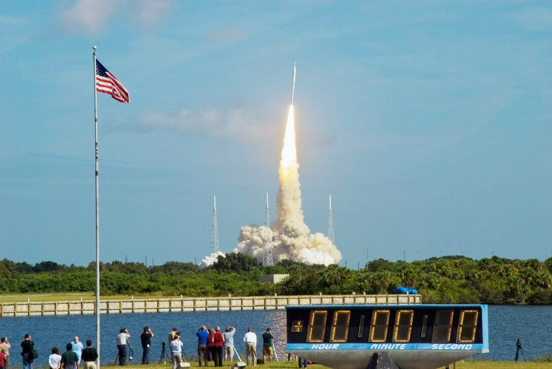 The stars and stripes on the American flag reflect NASA's commitment to teamwork as the Constellation Program's Ares I-X test rocket roars off Launch Complex 39B Oct. 28, 2009, at NASA's Kennedy Space Center in Florida. (NASA photo/Jim Grossmann)