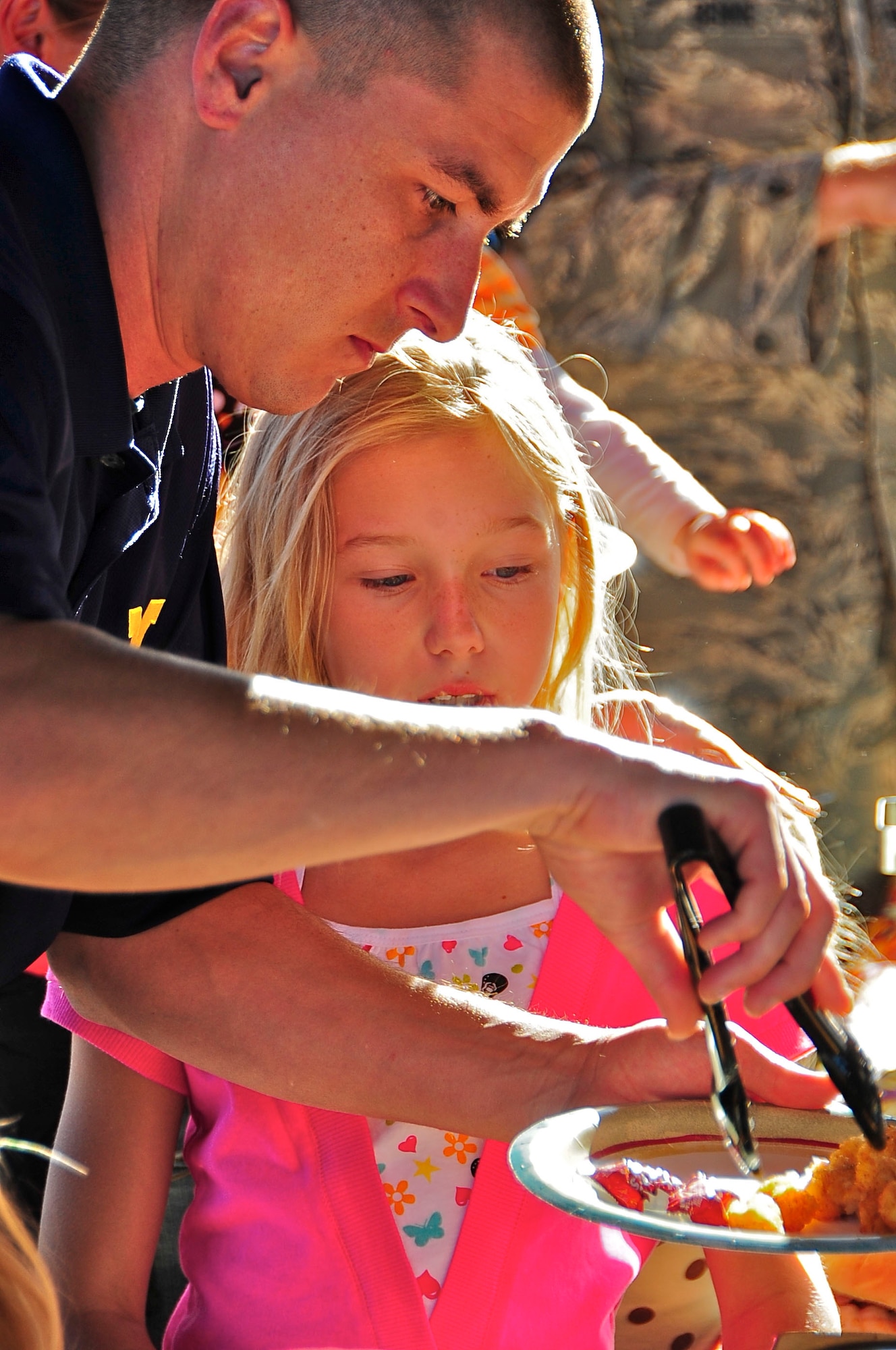 HOLLOMAN AIR FORCE BASE, N.M. -- Staff Sgt. Andrew Sylvester, 4th Space Control Squadron, gets a plate of food for his daughter, Allison, during the fall festival here Oct. 23. Free food was provided at the festival that was packed with family-friendly activities. The festival gave Team Holloman members an opportunity to relax with their families before the next day's open house events. (U.S. Air Force photo by Tech. Sgt. Chris Flahive)