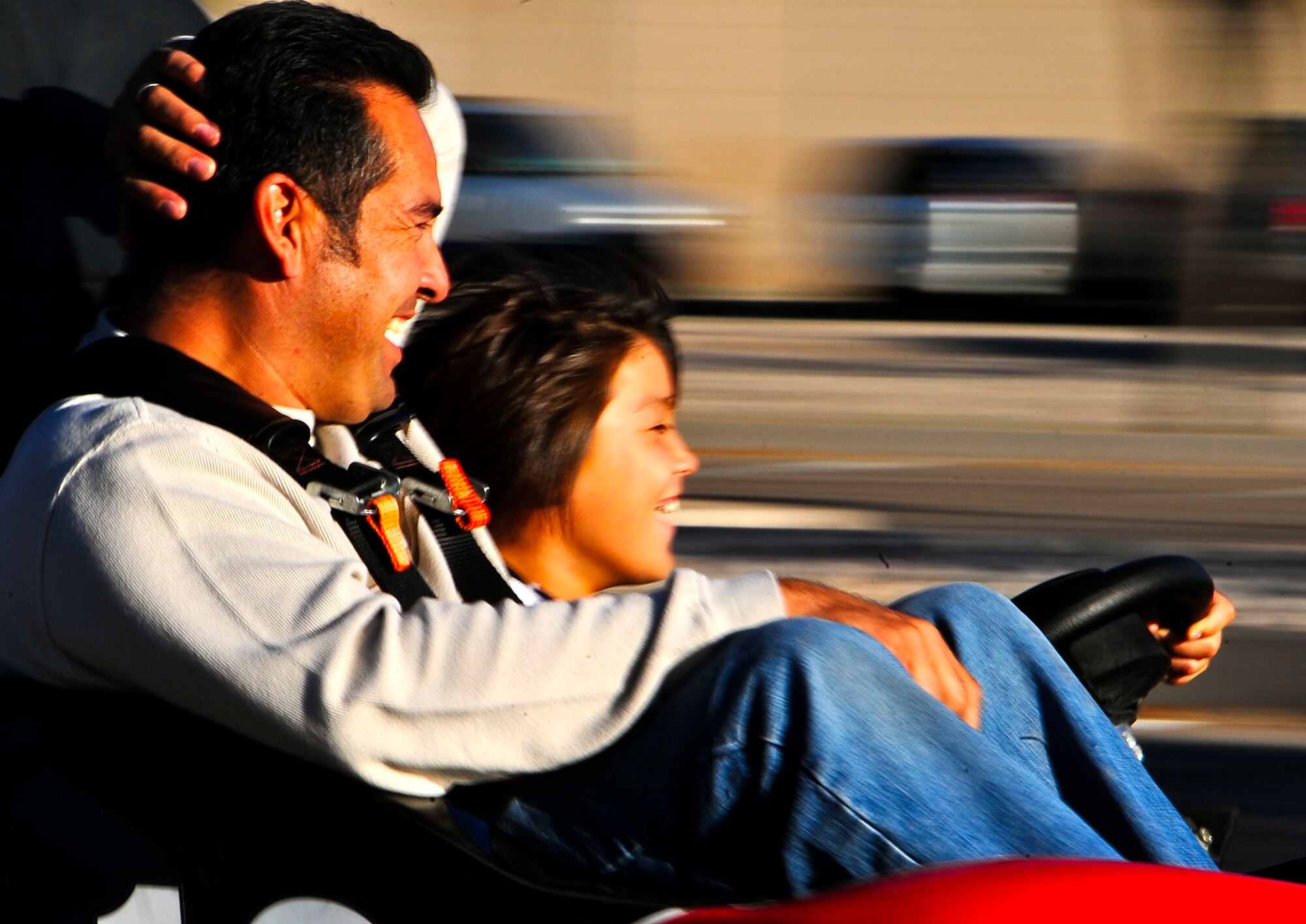 HOLLOMAN AIR FORCE BASE, N.M. -- Tony Lucero, 49th Civil Engineer Squadron, rides in a go kart while his son, Nicholas, drives during the fall festival here Oct. 23. More than 400 Team Holloman members attended the event during the day-long 49th Fighter Wing Next Generation Celebration. The festival also featured a sunset F-22A Raptor demonstration and a practice air show, giving the base an exclusive preview of a few aerial acts to be performed the next day at Holloman's Open House. (U.S. Air Force photo by Tech. Sgt. Chris Flahive)