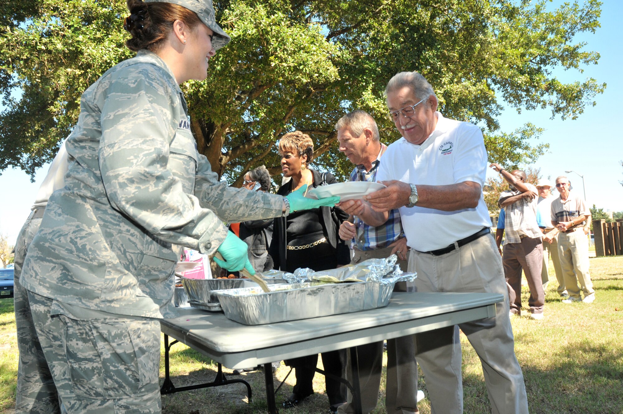 Maj. Stacey Van Orden, 81st Inpatient Operations Squadron, serves a plate of food to Francisco Archibeque at the retiree fish fry.  Mr. Archibeque, a retired master sergeant, lives in Bay St. Louis.  (U.S. Air Force photo by Adam Bond)