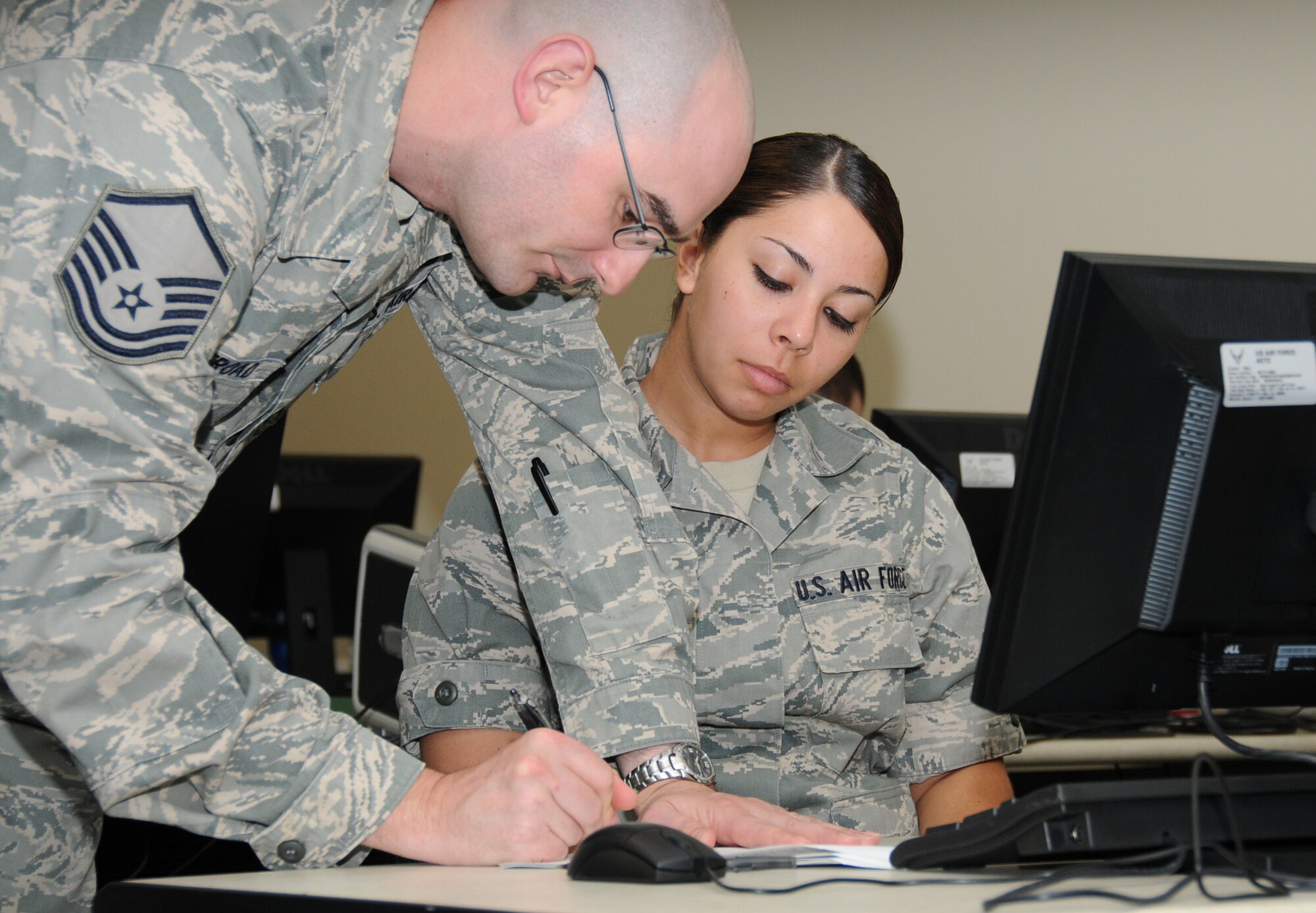 Master Sgt. Joseph Harkleroad goes over course materials with Airman Basic Devin Andrade Oct. 20 during the first cyber surety class.  Sergeant Harkleroad, 333rd Training Squadron, is a subject matter expert who’s serving in the 336th TRS during the course start-up.  In addition to nonprior service students, Sergeant Harkleroad also has 336th TRS instructors in his class.  (U.S. Air Force photo by Kemberly Groue)