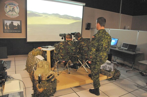 KIRTLAND AIR FORCE BASE, N.M. -- Joint Terminal Attack Controllers from the United Kingdom and Canada work on a scenario at the Joint Close Air Support Simulator at the Distributed Mission Operations Center on Sept. 23. JTACs from all four countries were at the DMOC to train together on two separate simulators during Coalition Virtual Flag 09-4. Another JTAC participated in the exercise on a sim in Canada. (Air Force photo by Ken Moore)