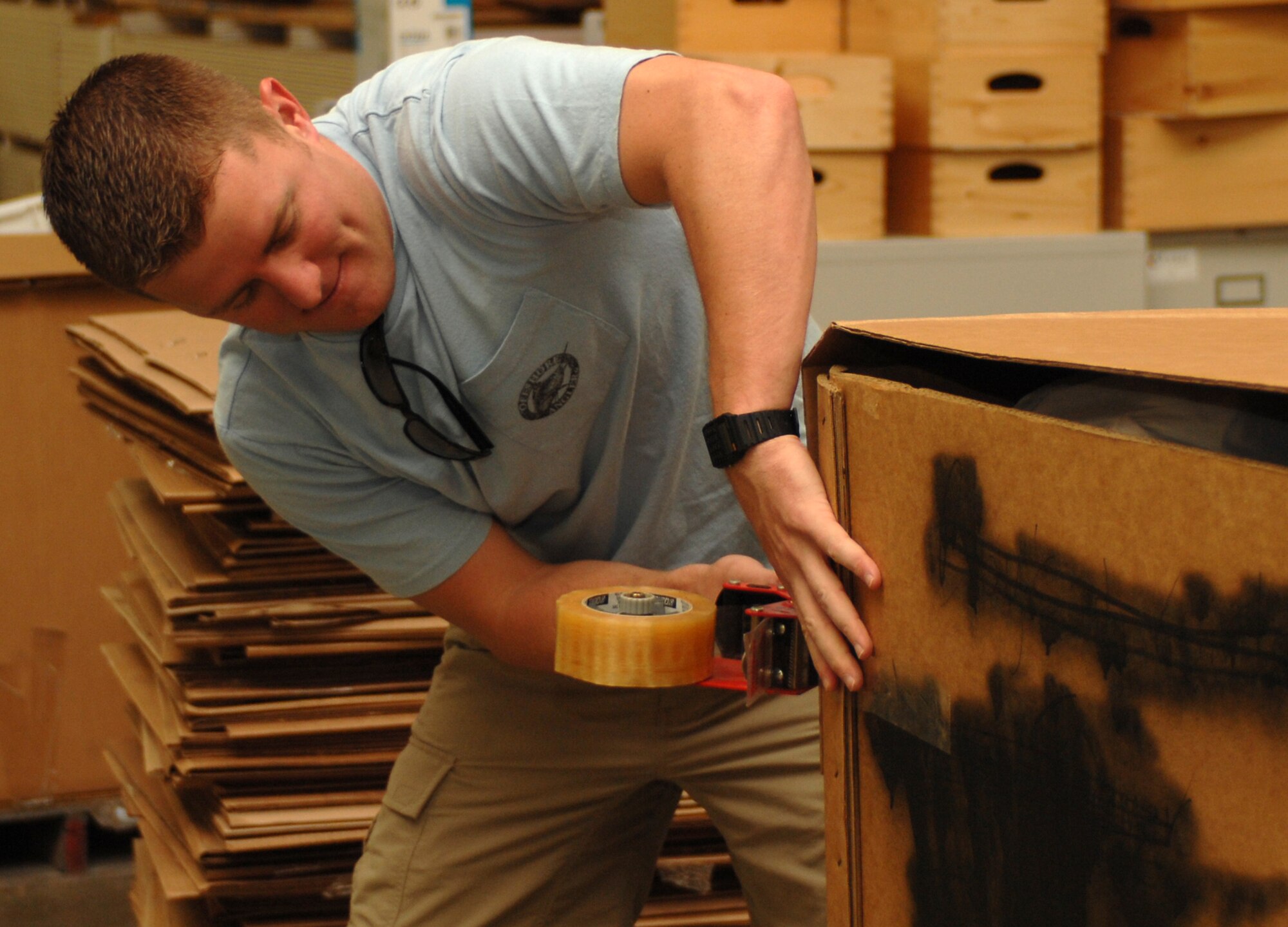 1st Lt. Michael Malone, 333rd Fighter Squadron pilot, tapes a box full of winter clothing headed to Afghanistan during the Stop Hunger Now event at the MERCI Mission Center in Goldsboro, N.C., Oct. 24, 2009. Approximately 200 volunteers from the Seymour Johnson and Goldsboro communities gathered to package 115,000 meals and thousands of pounds of clothing for the people of Afghanistan. (U.S. Air Force photo/Staff Sgt. Heather Stanton)