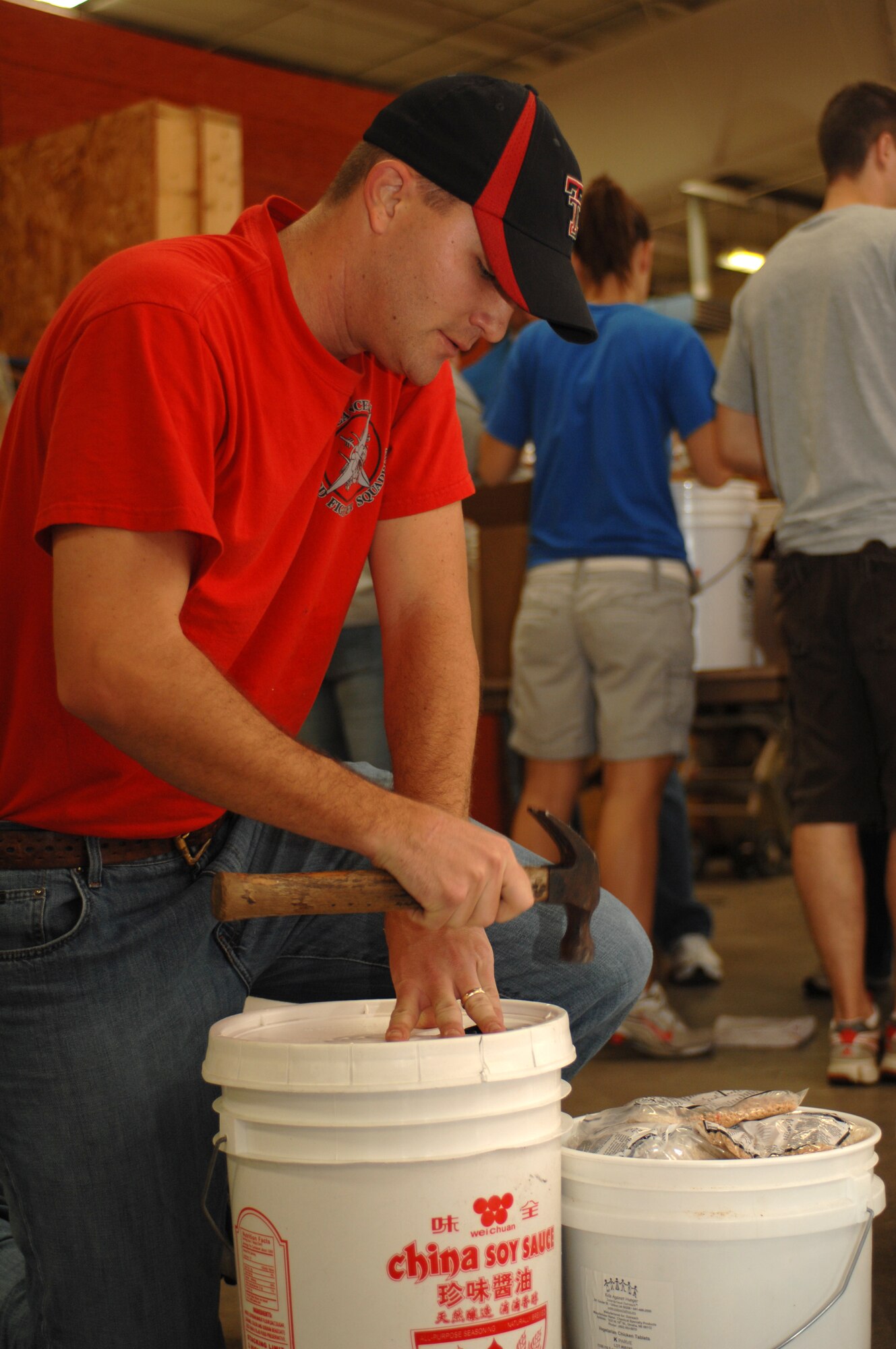 1st Lt. Michael Hefferly, 333rd Fighter Squadron weapon system officer, hammers down a bucket full of rice- and soy-based meals for shipment to Afghanistan during the Stop Hunger Now event at the MERCI Mission Center in Goldsboro, N.C., Oct. 24, 2009. The items are shipped to Afghanistan courtesy of the Denton Program, which allows private U.S. citizens and organizations to use space available on U.S. military cargo planes to transport humanitarian goods and supplies to countries in need. (U.S. Air Force photo/Staff Sgt. Heather Stanton)