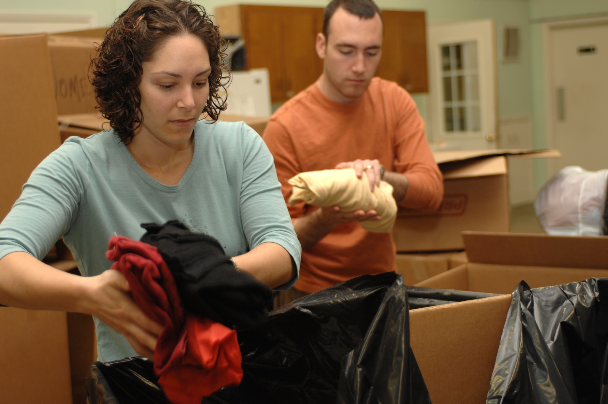 Beth Teegarden and her husband, Capt. Conor Teegarden, 333rd Fighter Squadron weapon system officer, package winter clothing into large bags headed to Afghanistan during the Stop Hunger Now event at the MERCI Mission Center in Goldsboro, N.C., Oct. 24, 2009. The event transpired as an idea from Rev. Billy Olsen, Pine Forest United Methodist Church pastor, and the Seymour Johnson chaplains as a way to bring together members of the base and local community. (U.S. Air Force photo/Staff Sgt. Heather Stanton)