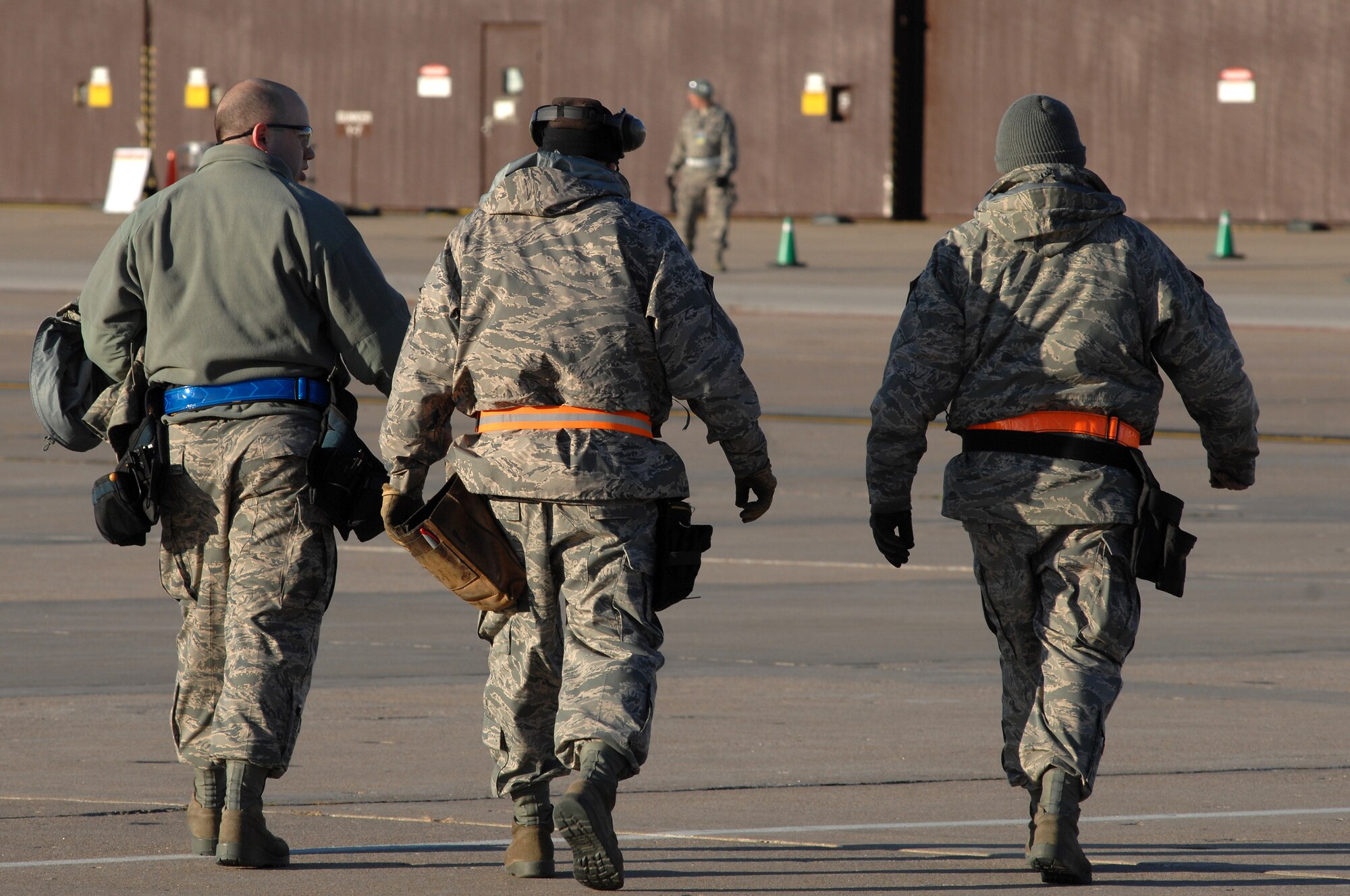 WHITEMAN AIR FORCE BASE, Mo. - Tech Sgts. Shaun McCrea, Wesley Peel and Staff Sgt. Dean Gross, 442nd Fighter Wing crew chiefs, walk off the flight line back to the hanger to retrieve more tools for A-10 Thunderbolt II maintenance during an Operational Readiness Inspection, Oct. 24. 442nd FW personnel worked around the clock in cold and wet weather conditions during the four-day exercise. The ORI prepared Airmen for real-world deployment situations such as chemical and biological attacks and other scenarios. (U.S. Air Force photo/Senior Airman Kenny Holston)(Released) 
