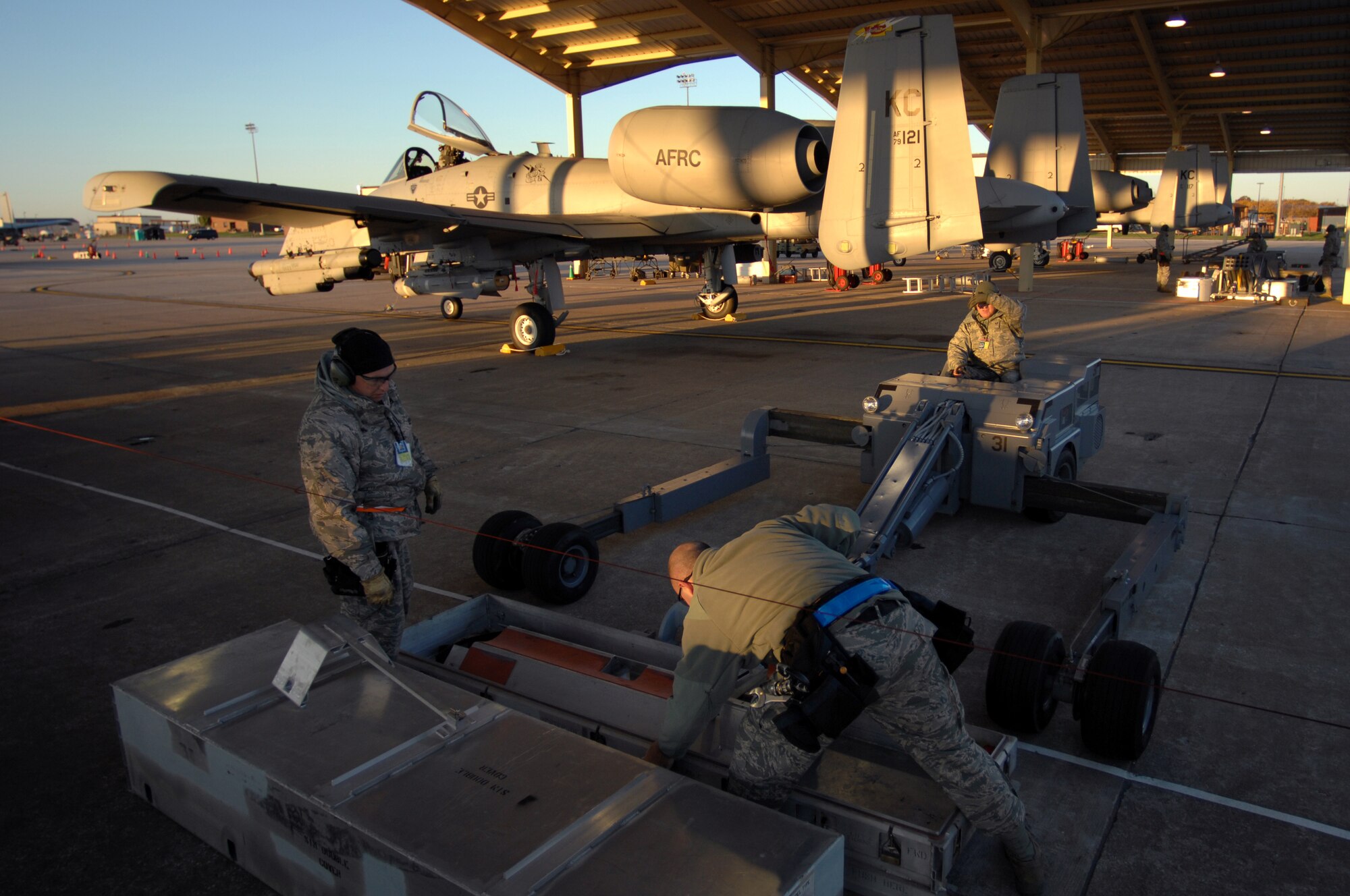 WHITEMAN AIR FORCE BASE, Mo. - Tech Sgts. Shaun McCrea, Wesley Peel and Staff Sgt. Dean Gross, 442nd Fighter Wing, prepare an aluminum munitions case for a weapons download during an Operational Readiness Inspection, Oct. 24. 442nd FW personnel worked around the clock in cold and wet weather conditions during the four-day exercise. The ORI prepared Airmen for real-world deployment situations such as chemical and biological attacks and other scenarios. (U.S. Air Force photo/Senior Airman Kenny Holston)(Released) 