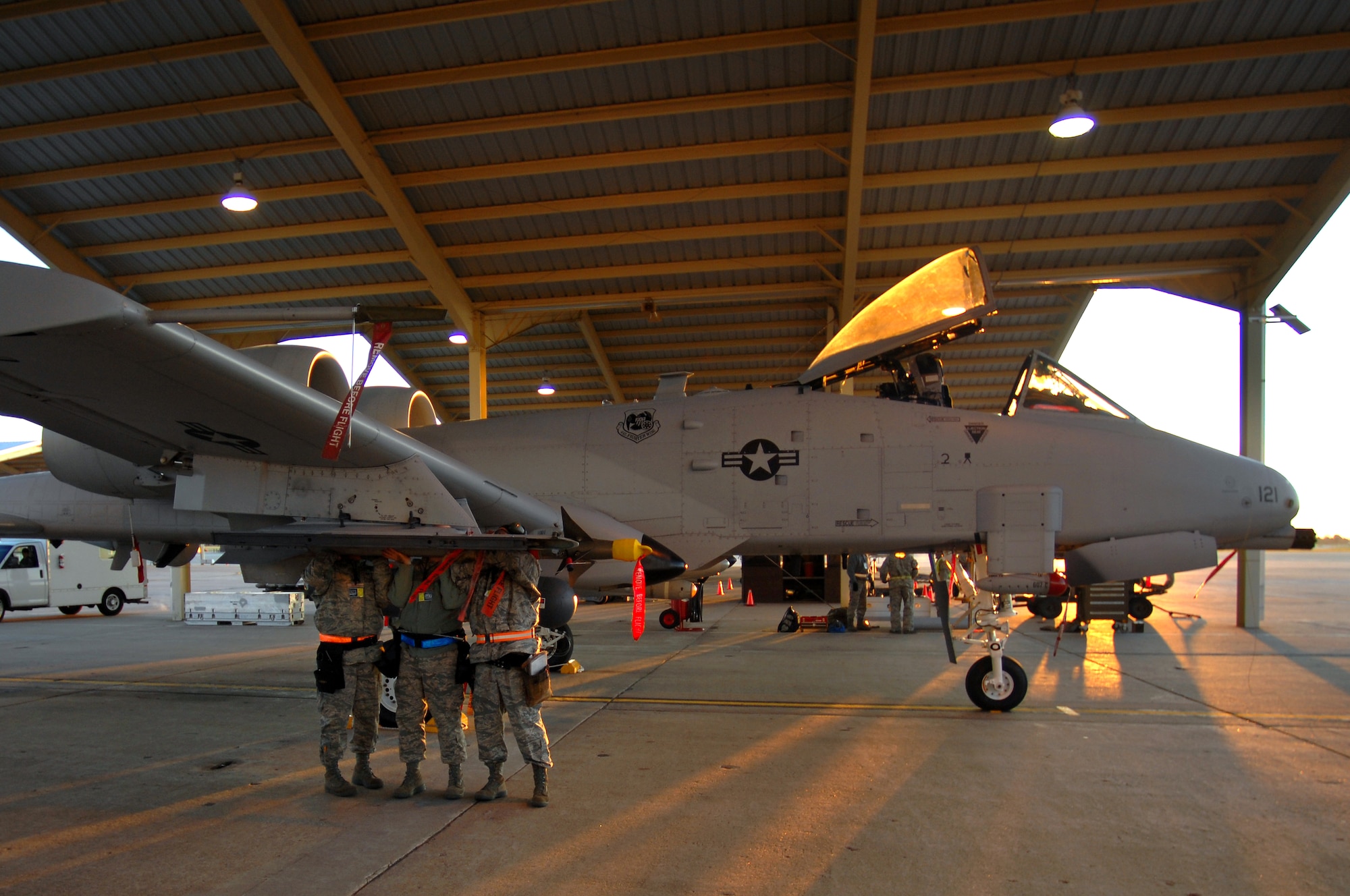 WHITEMAN AIR FORCE BASE, Mo. - Morning sunlight slips into the A-10 Thunderbolt II hanger as Tech Sgts. Shaun McCrea, Wesley Peel and Staff Sgt. Dean Gross, 442nd Fighter Wing, work together to download a weapon from the wing of an A-10 Thunderbolt II during an Operational Readiness Inspection, Oct. 24. 442nd FW personnel worked around the clock in cold and wet weather conditions during the four-day exercise. The ORI prepared Airmen for real-world deployment situations such as chemical and biological attacks and other scenarios. (U.S. Air Force photo/Senior Airman Kenny Holston)(Released) 