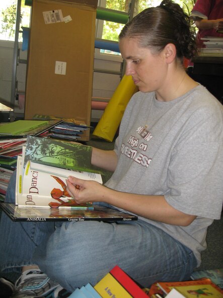 Capt. Julie Harrison, 4th Force Support Squadron manpower and personnel flight chief, checks books for tears and rips before placing them on new shelves at the Seymour Johnson Air Force Base Child Development Center as part of “Make a Difference Day” Oct. 24, 2009. More than 75 volunteers spent the day using the necessary elbow grease to complete the CDCs “To Do List.” (U.S. Air Force photo/Senior Airman Courtney Richardson)